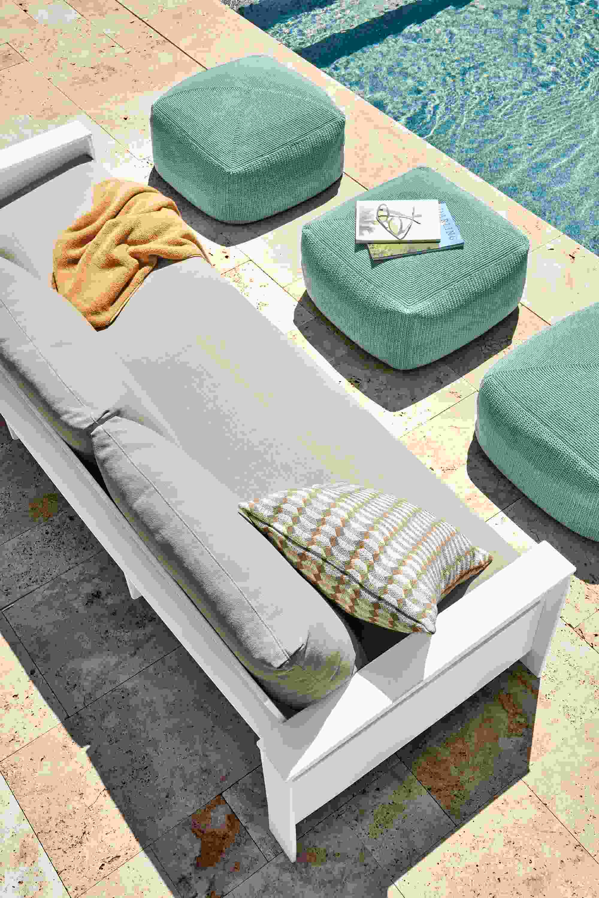 Rayo 92-inch outdoor sofa in White with Niro Beige cushions and three Zena outdoor poufs in spa.