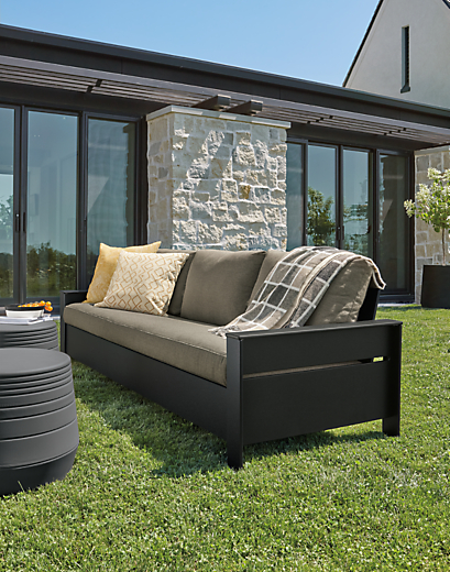 Rayo 92-inch outdoor sofa in black with Pelham charcoal cushions and two cusp round stools in umber.
