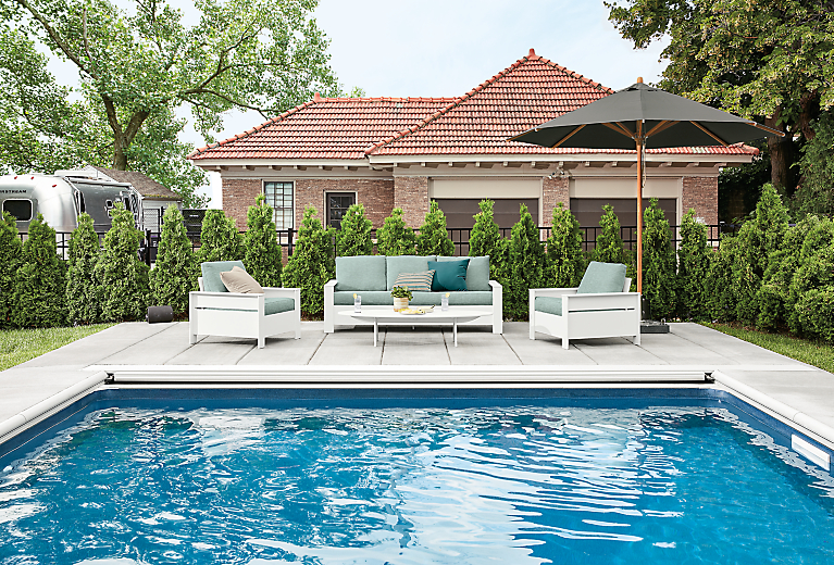 Detail of Rayo sofa and chairs with Cirro umbrella at poolside.