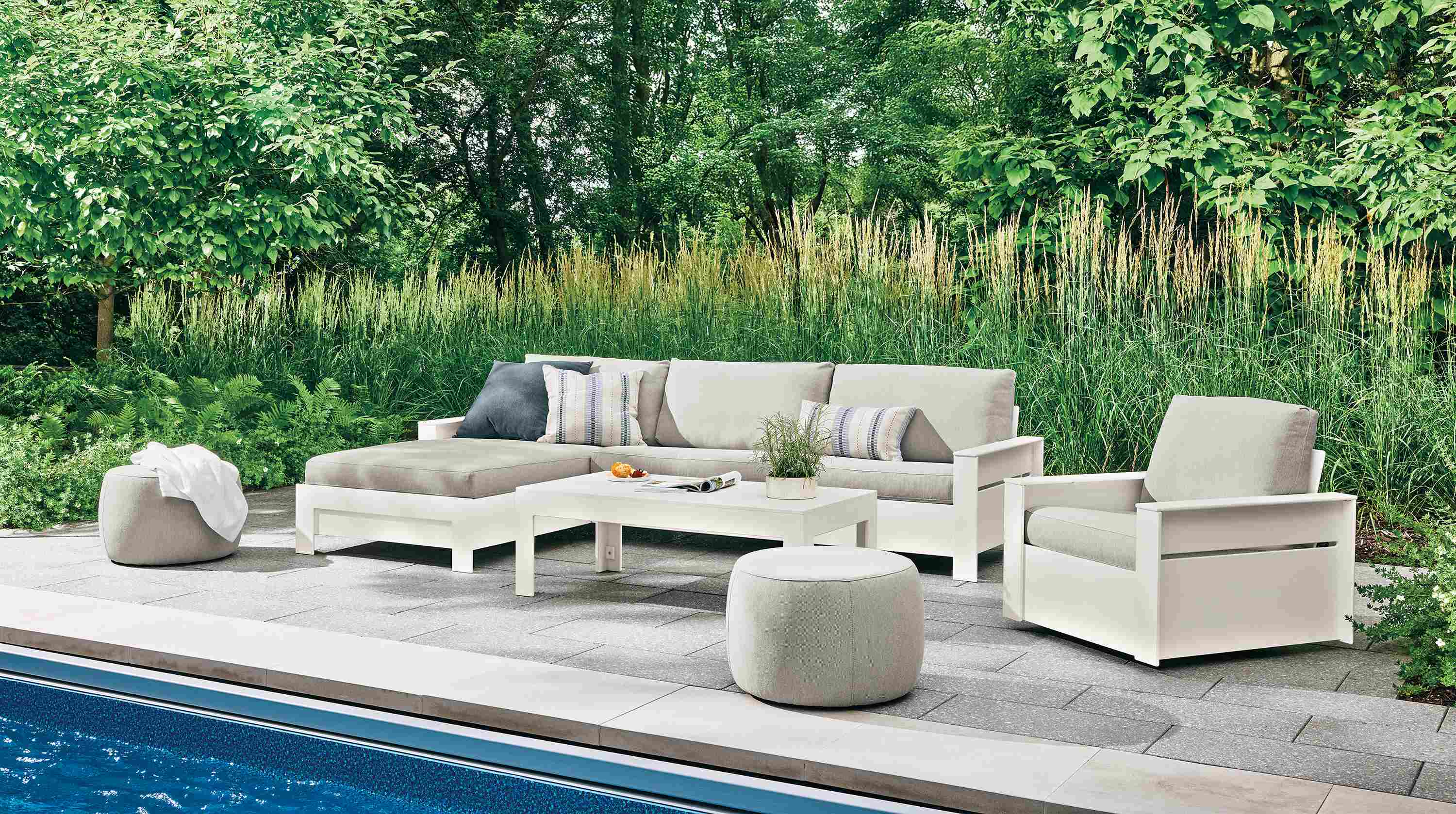 Poolside patio with Rayo left-arm chaise and swivel chair in Mist Grey and white HDPE and Henry coffee table.
