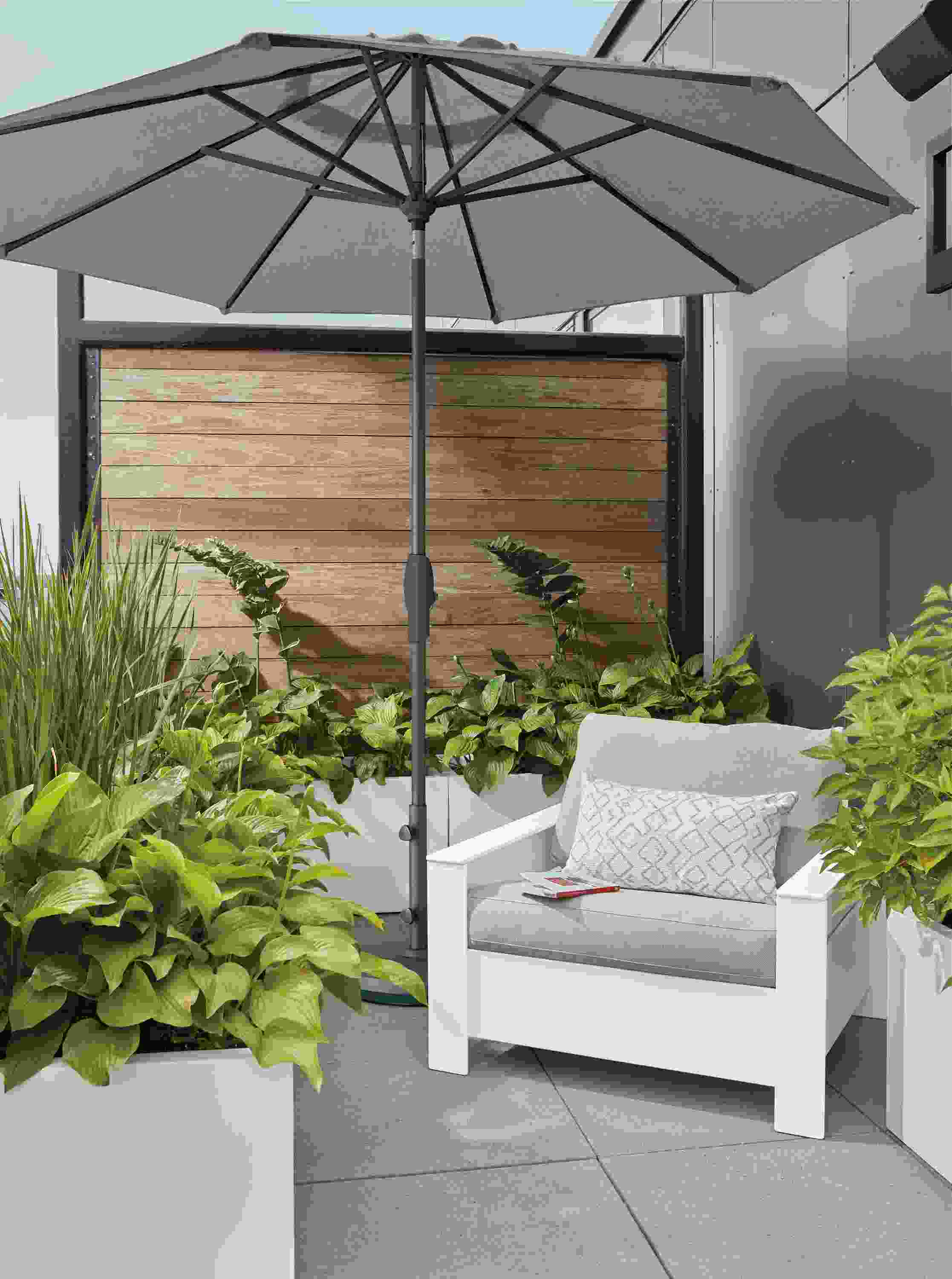 Patio with Rayo lounge chair in white with Mist grey cushions and Oahu umbrella in Tavros Taupe fabric.