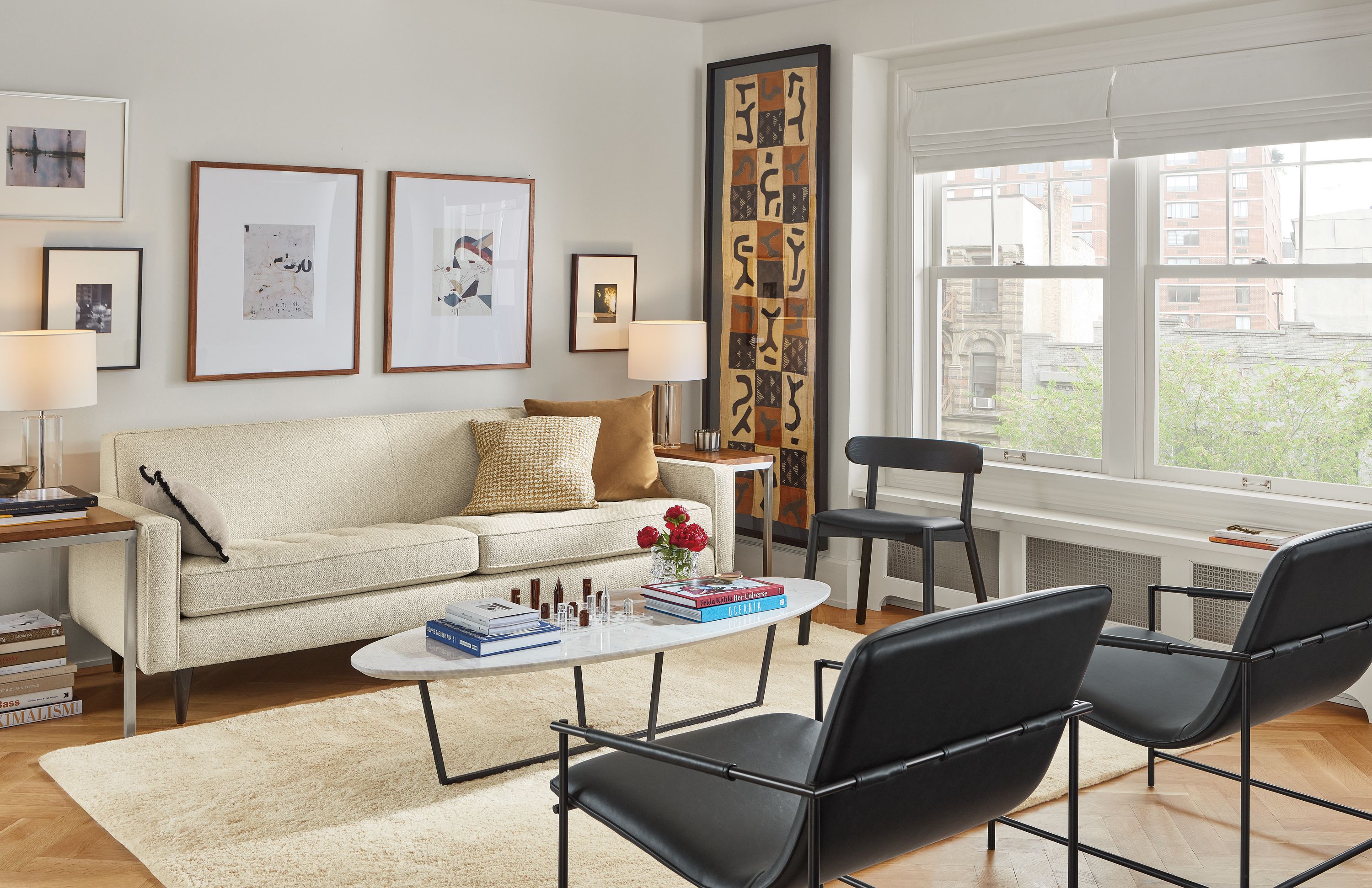 living room featuring reese two-cushion sofa in orla ivory fabric and two dina lounge chairs in synthetic black leather