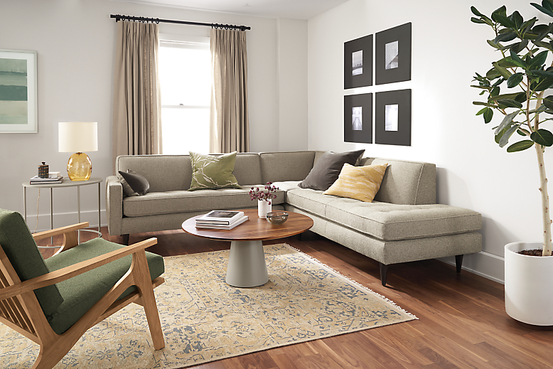 Living room setting with Reese 3-piece sectional in Tatum grey and Sanna chair in white oak and Hines spruce.