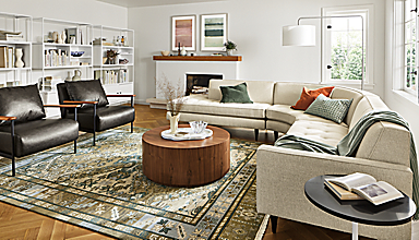 Living room with Reese 115-wide three-piece curved sectional in orla ivory, Xavier chair in Palermo charcoal leather.