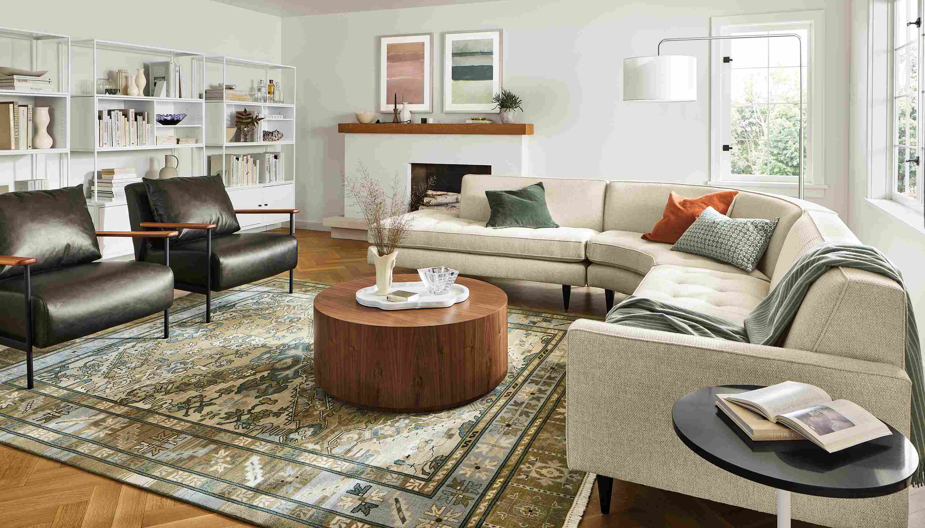 Living room with Reese 115-wide 3-piece curved sectional in Orla Ivory, Xavier chair in Palermo charcoal leather.