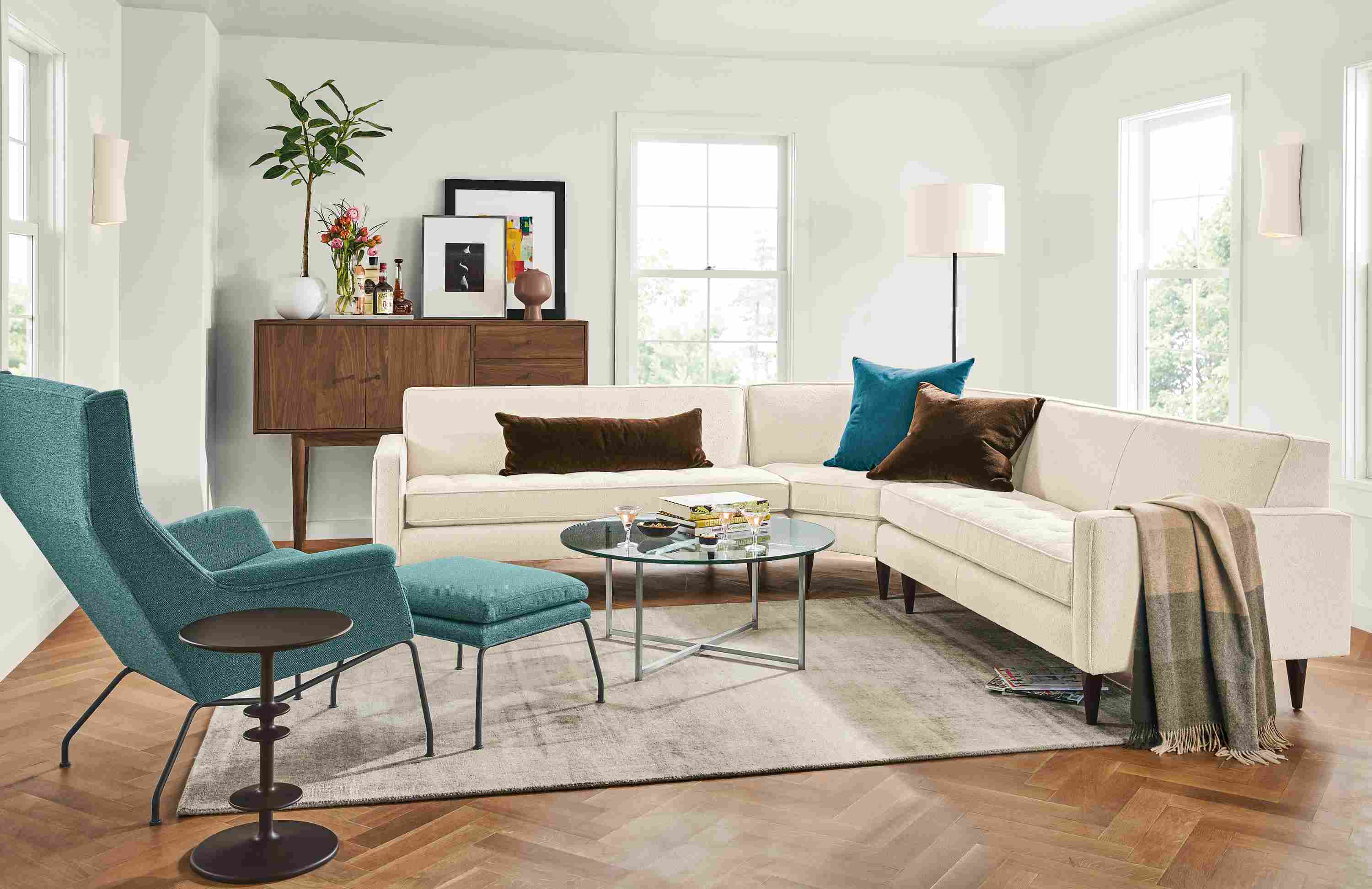 Living room with Reese 3-piece curved sectional in Declan Ivory and Aidan chair and ottoman in Tatum Teal.