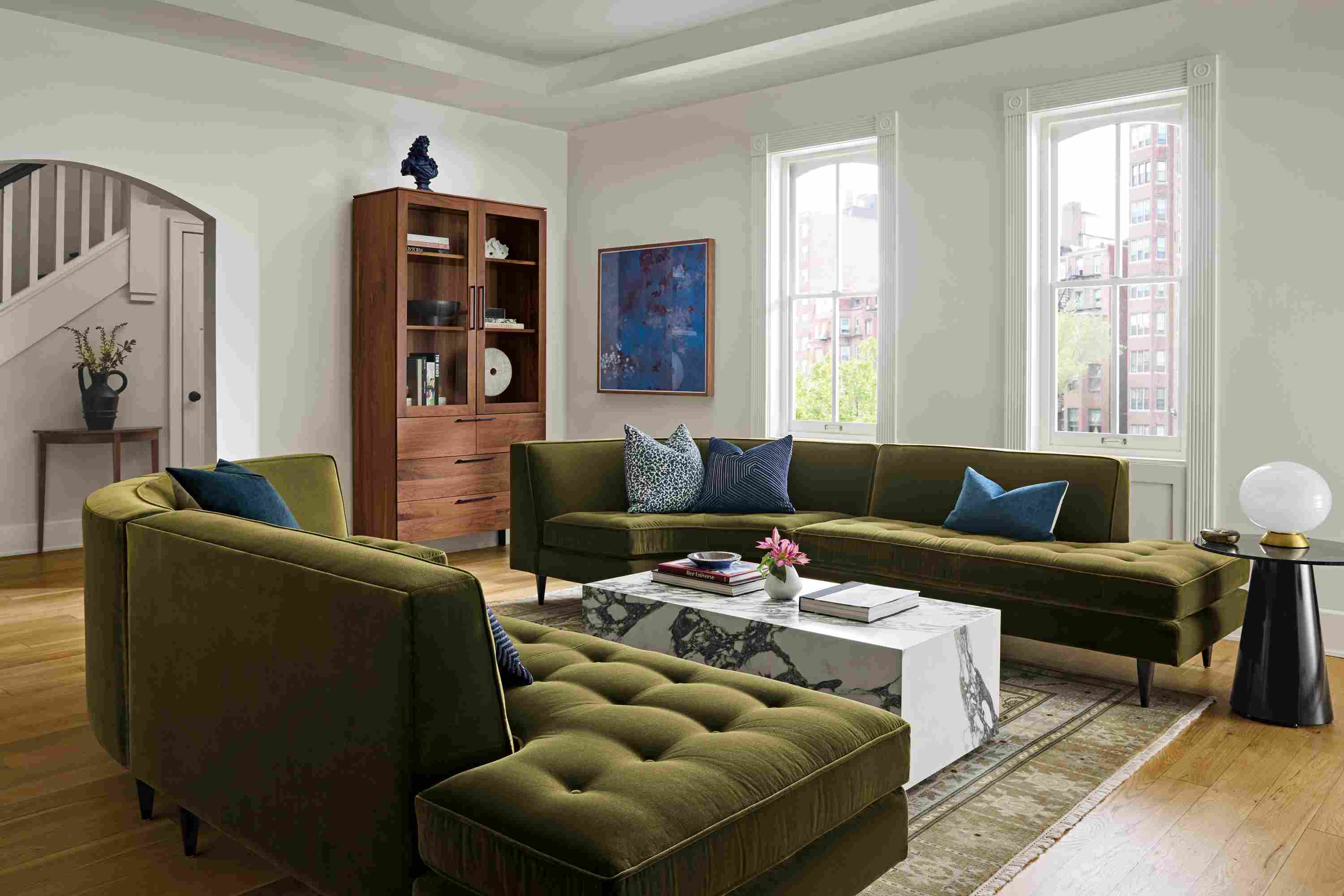 Large living room with 2 Reese curved sectional sofas in Redding Olive and a Leona coffee table in matte marbled white/charcoal.