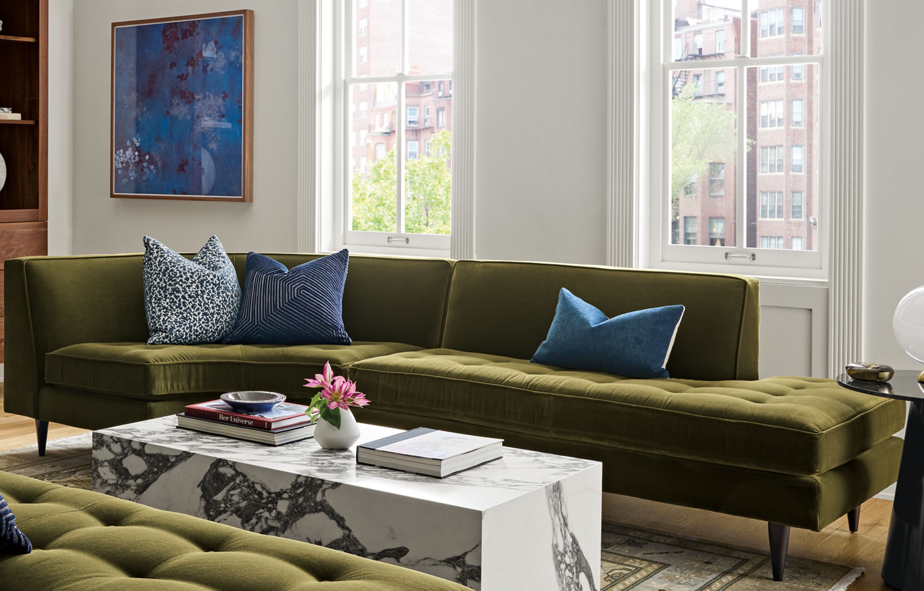 Large living room with 2 Reese curved sectional sofas in Redding Olive and a Leona coffee table in matte marbled white/charcoal.