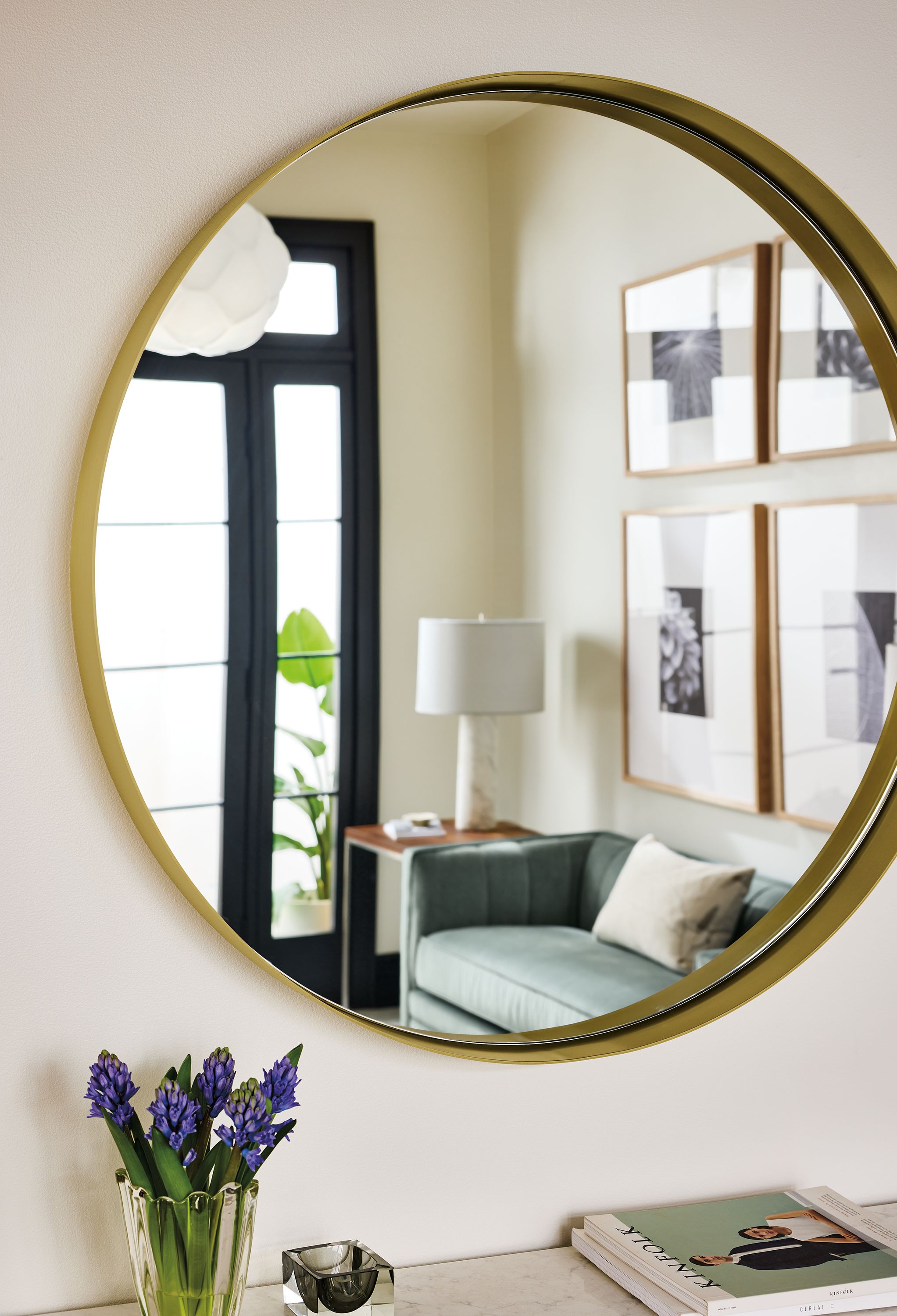 Detail of reeves 36.5-diameter mirror in brushed gold and reflection of Carlisle 60-wide bench in Windsor Cloud.