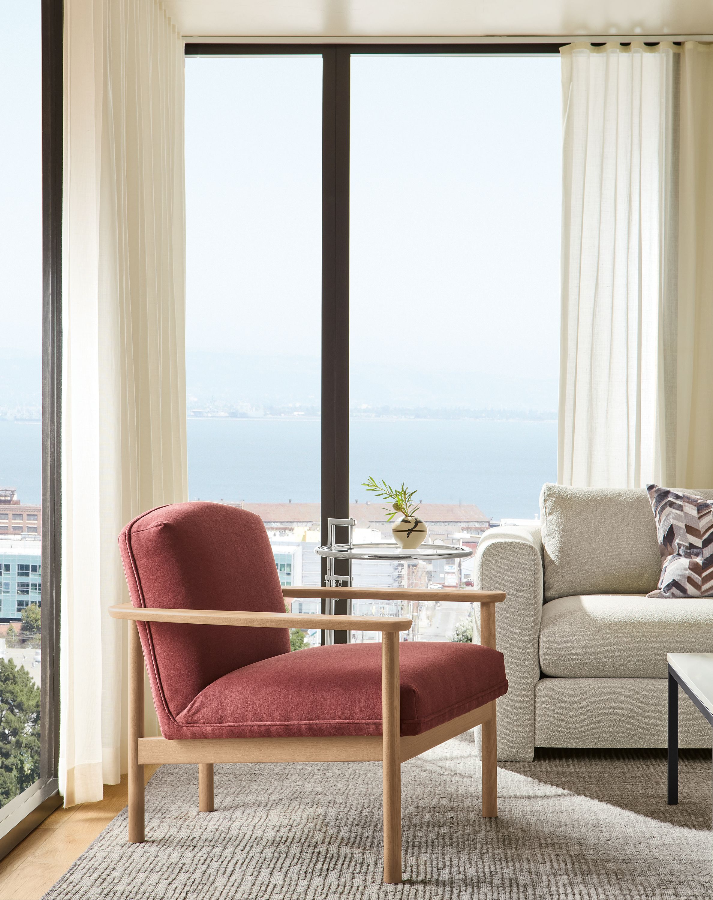 Hi-rise apartment living room corner with Renew chair in Terra Clay and Artis rug in grey.