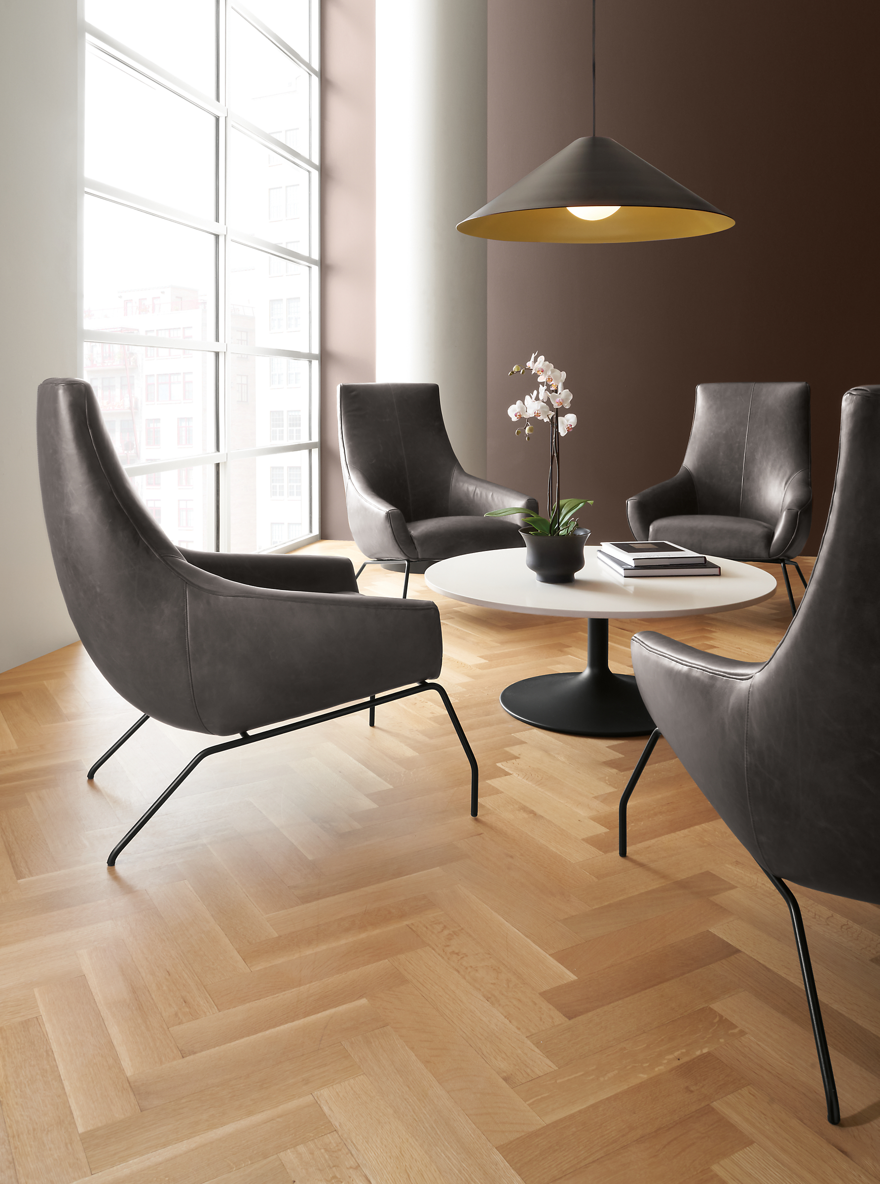 Rhodes leather chairs in Vento smoke with aria coffee table in graphite base with White top.