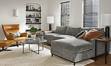 Living room with Robin 116-inch Sofa with Right-Arm Chaise in Mori Fabric, classic coffee table, Boden Swivel chair in Vento Leather.