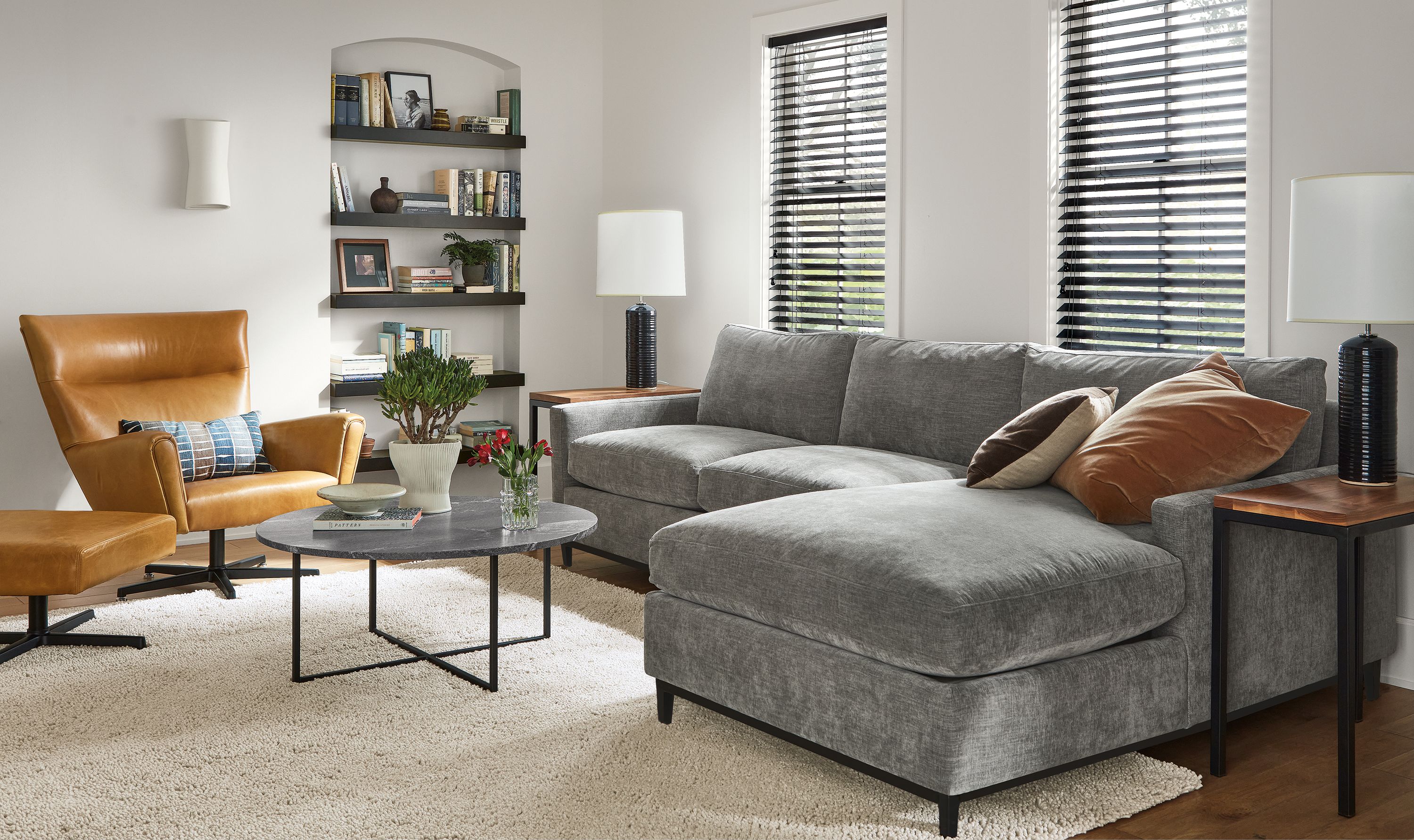 Living room with Robin 116-inch Sofa with Right-Arm Chaise in Mori Fabric, classic coffee table, Boden Swivel chair in Vento Leather.