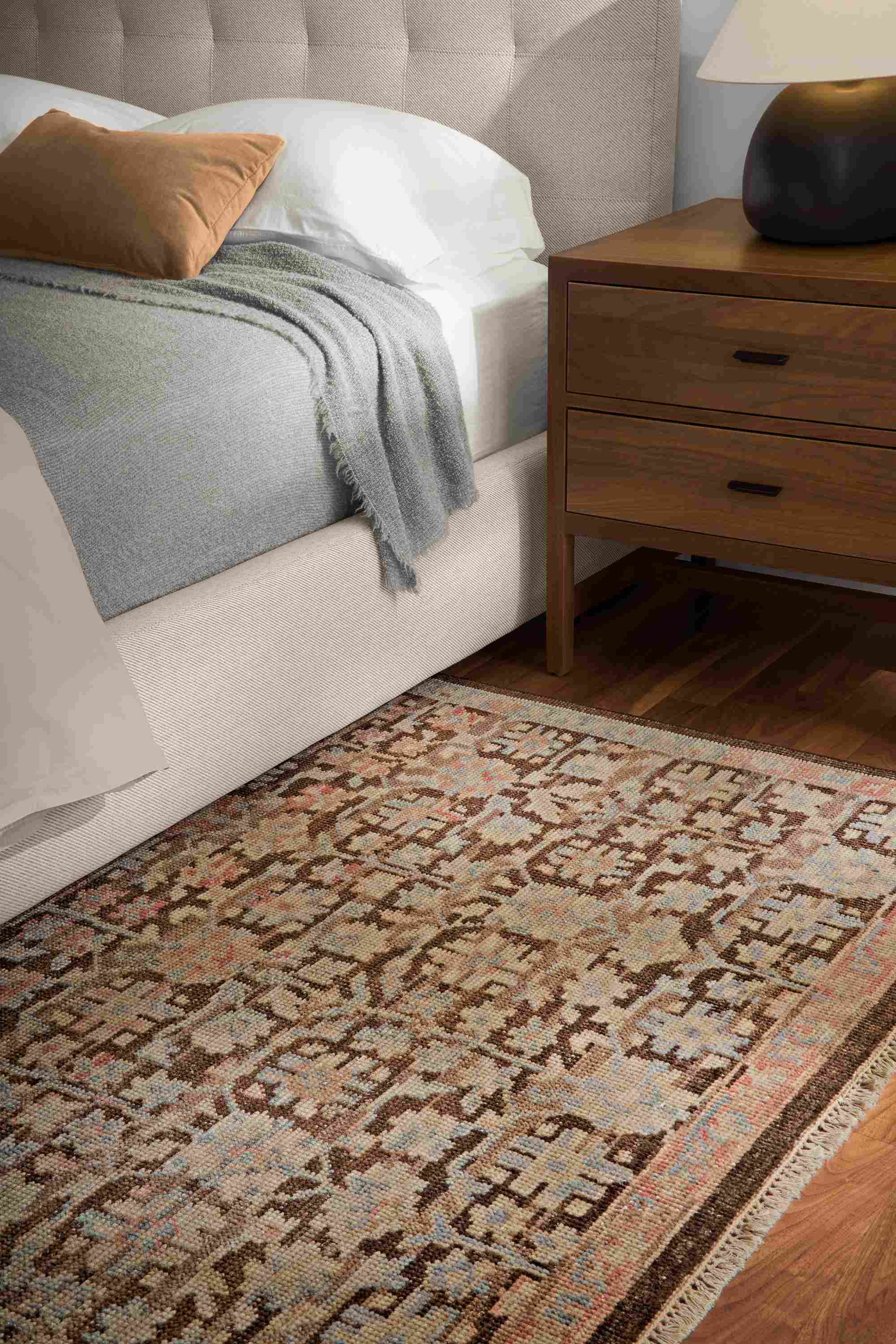 Bedroom with detail in Rosalie rug in petal, Avery queen bed in Derry Flax and Berkeley nightstand in walnut.