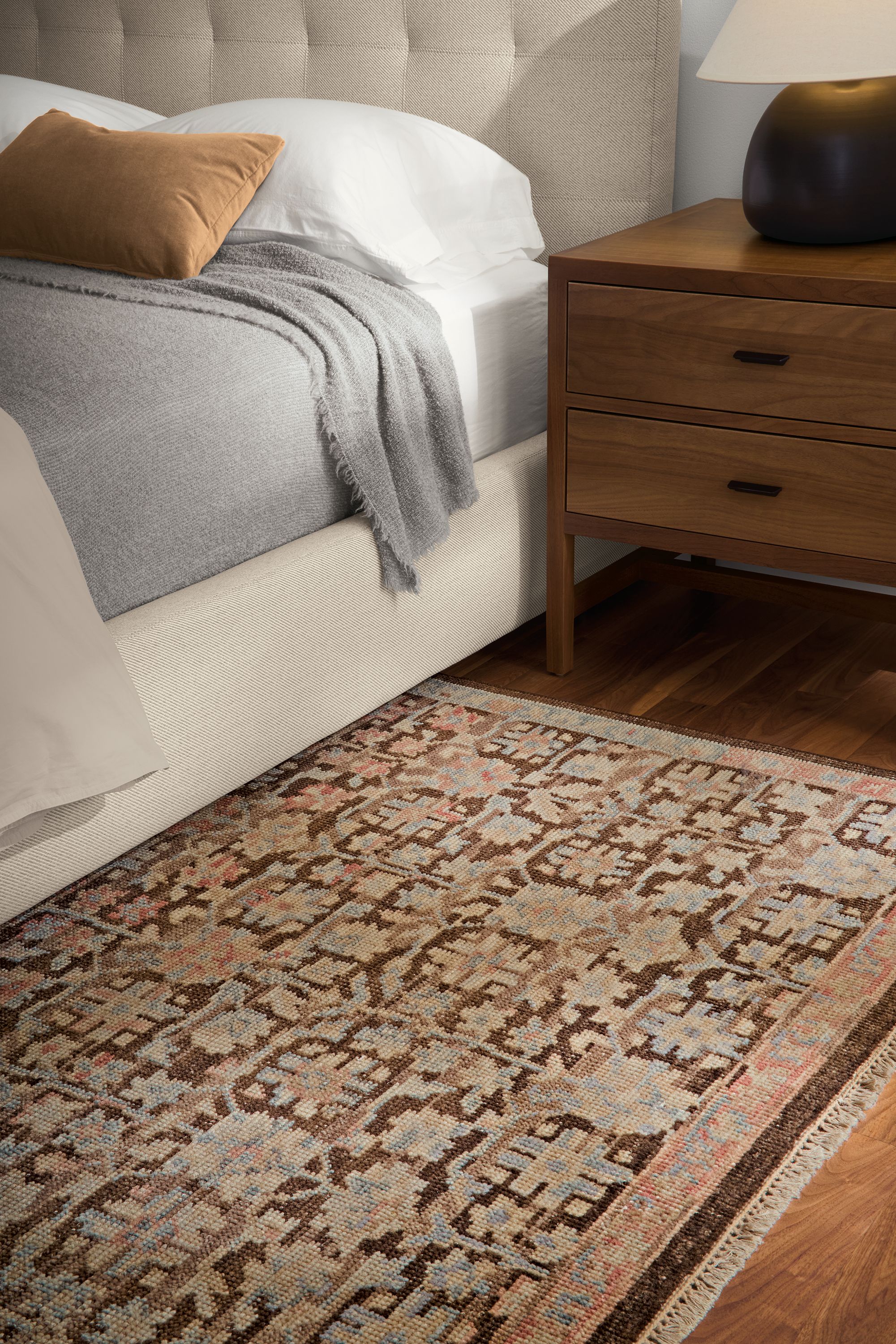 Bedroom with detail in Rosalie rug in petal, Avery queen bed in Derry Flax and Berkeley nightstand in walnut.