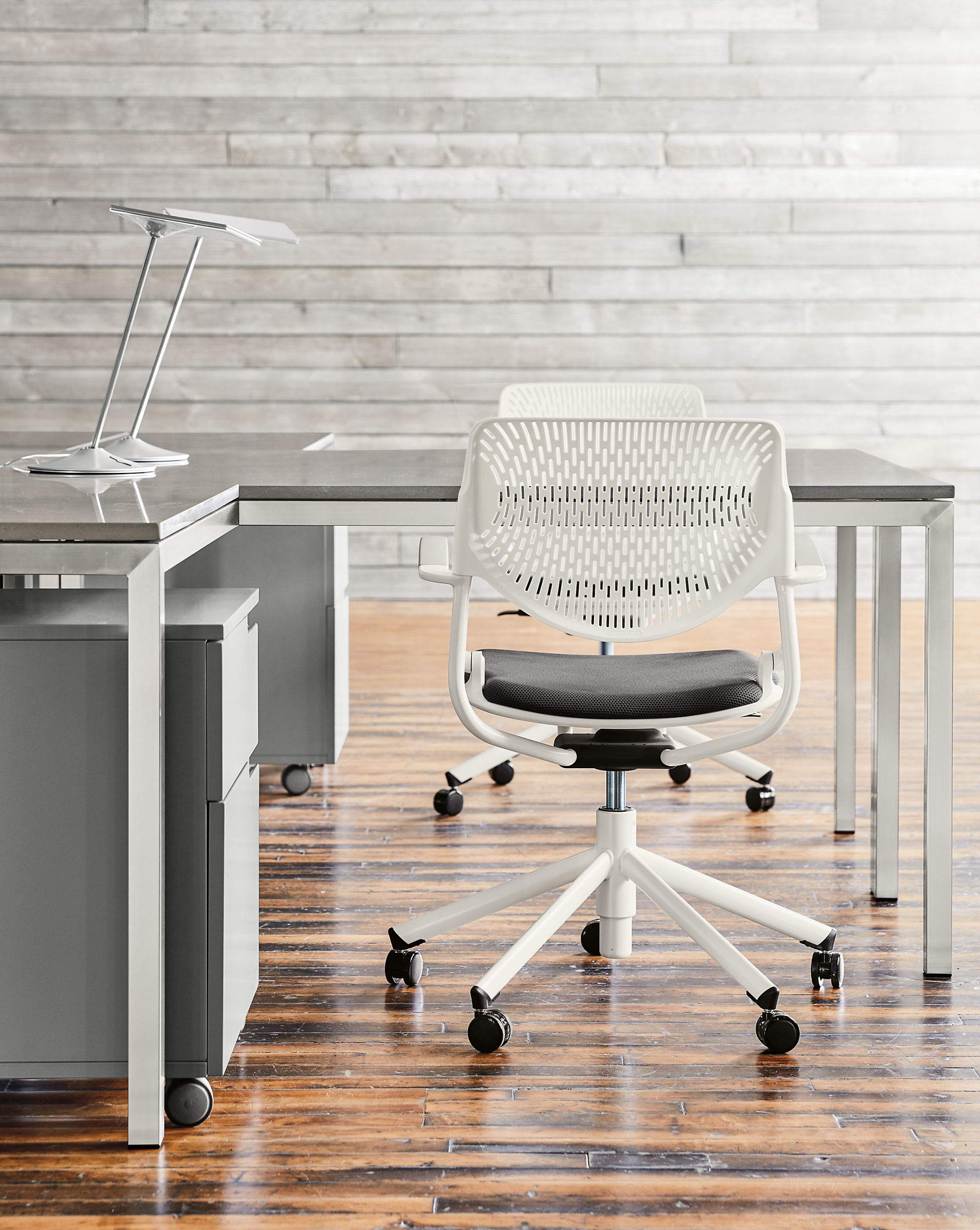 Detail of two Runa swivel office chairs in white with grey seat.