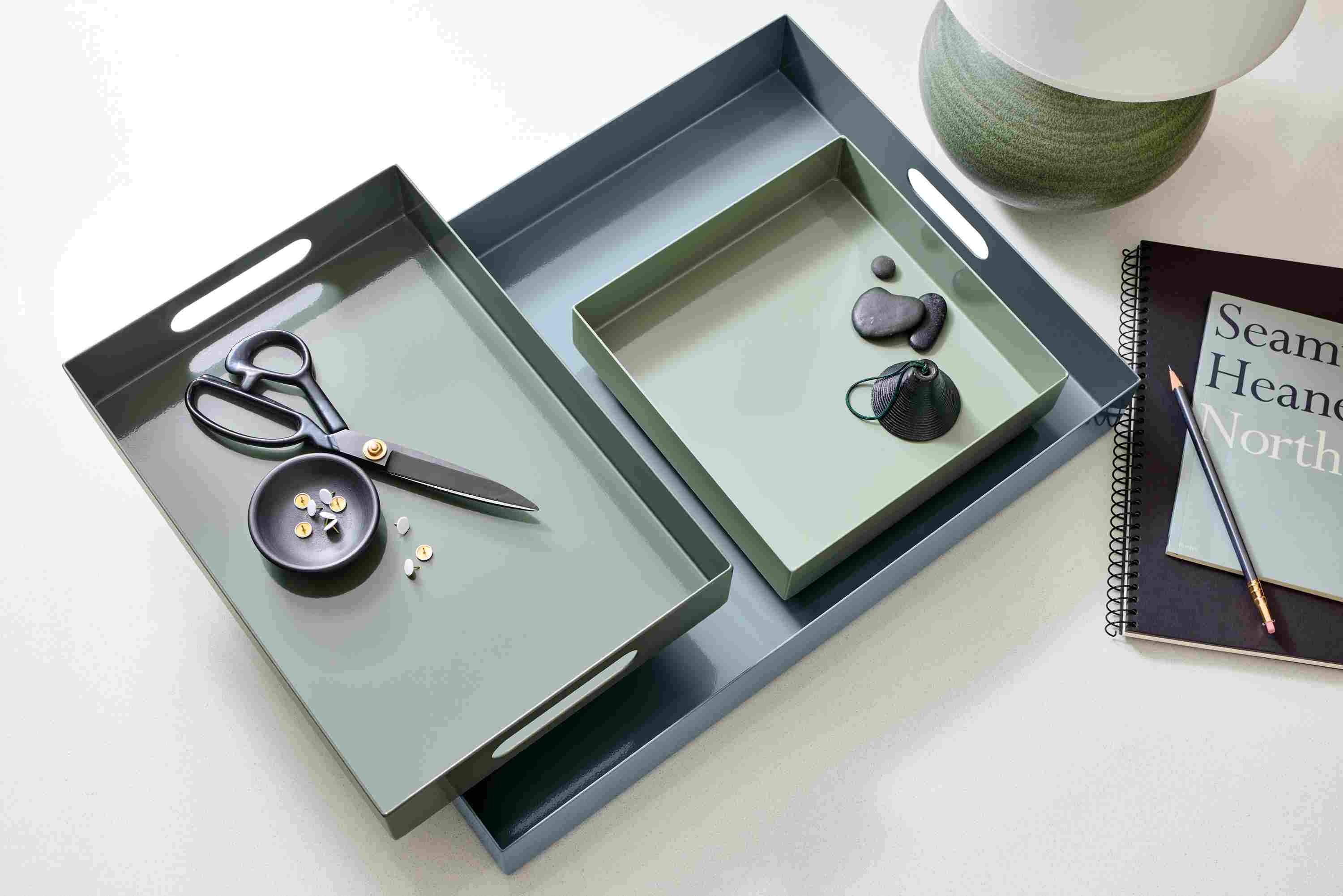 High-Angle view of set of 3 Russell Trays Lakeside palette of cadet, spruce and sage on an Aria white quartz tabletop.