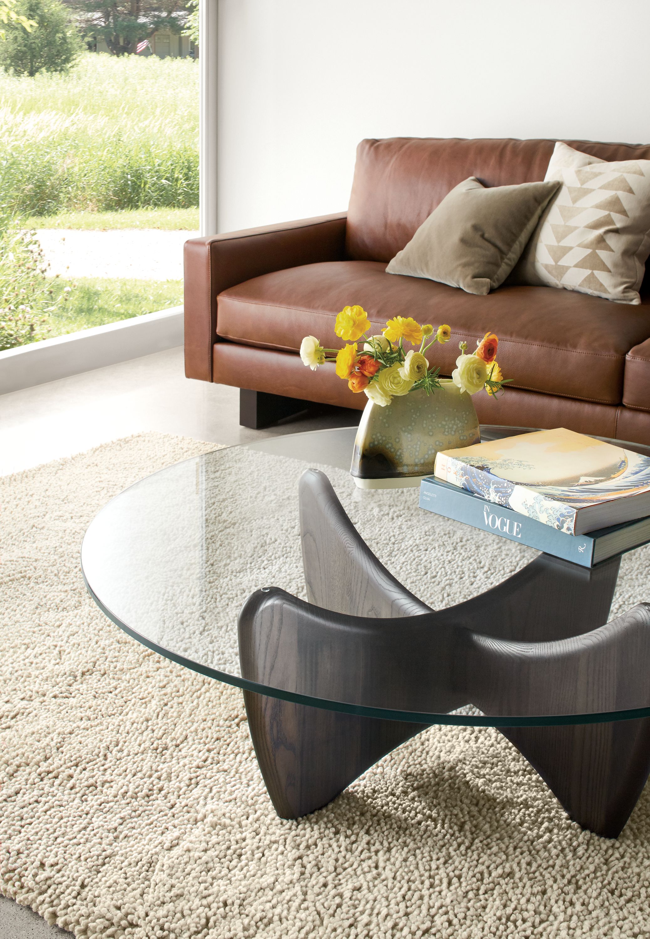 Detail of Sanders round cocktail table in charcoal and clear glass in living room.