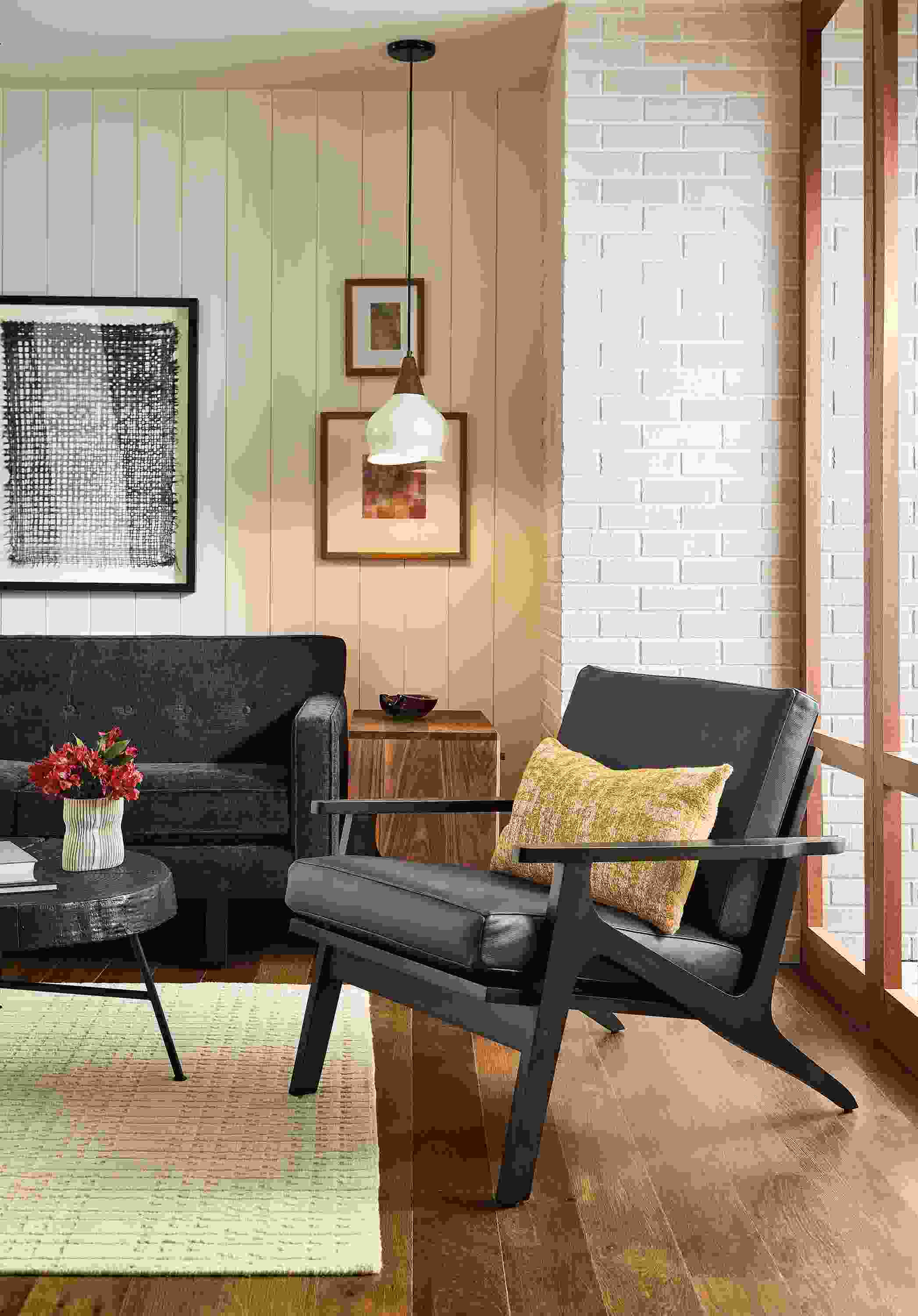 Living room with Sanna chair in Laino Black leather and Andre sofa in Mori Navy.
