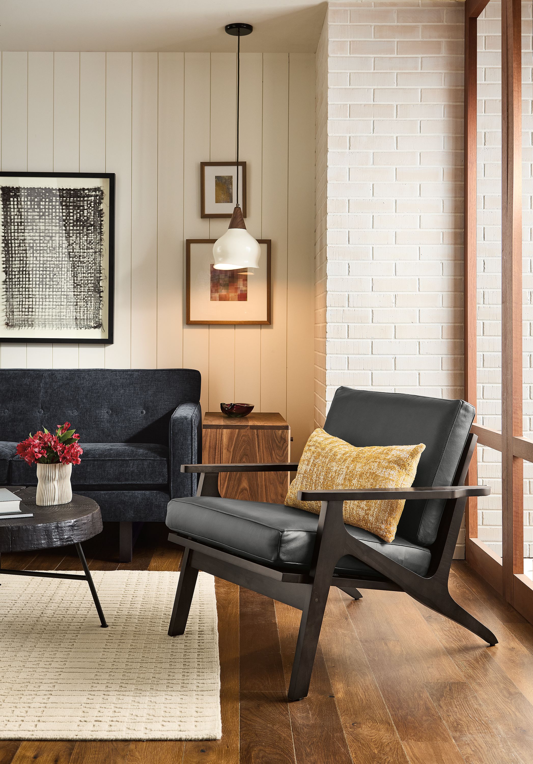 Living room with Sanna chair in Laino Black leather and Andre sofa in Mori Navy.