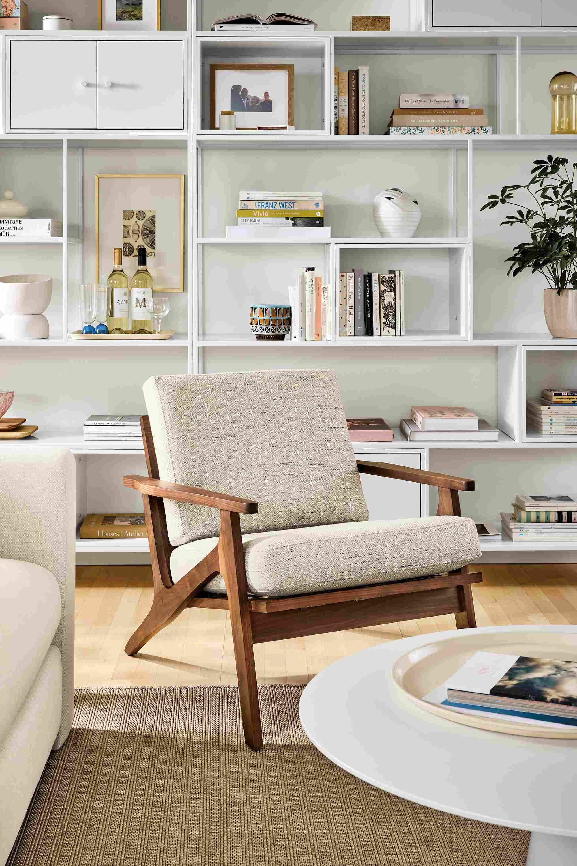 Living room with Sanna chair in Kinsey Oatmeal, Decker coffee table in white and foshay bookcases in white with white inserts.