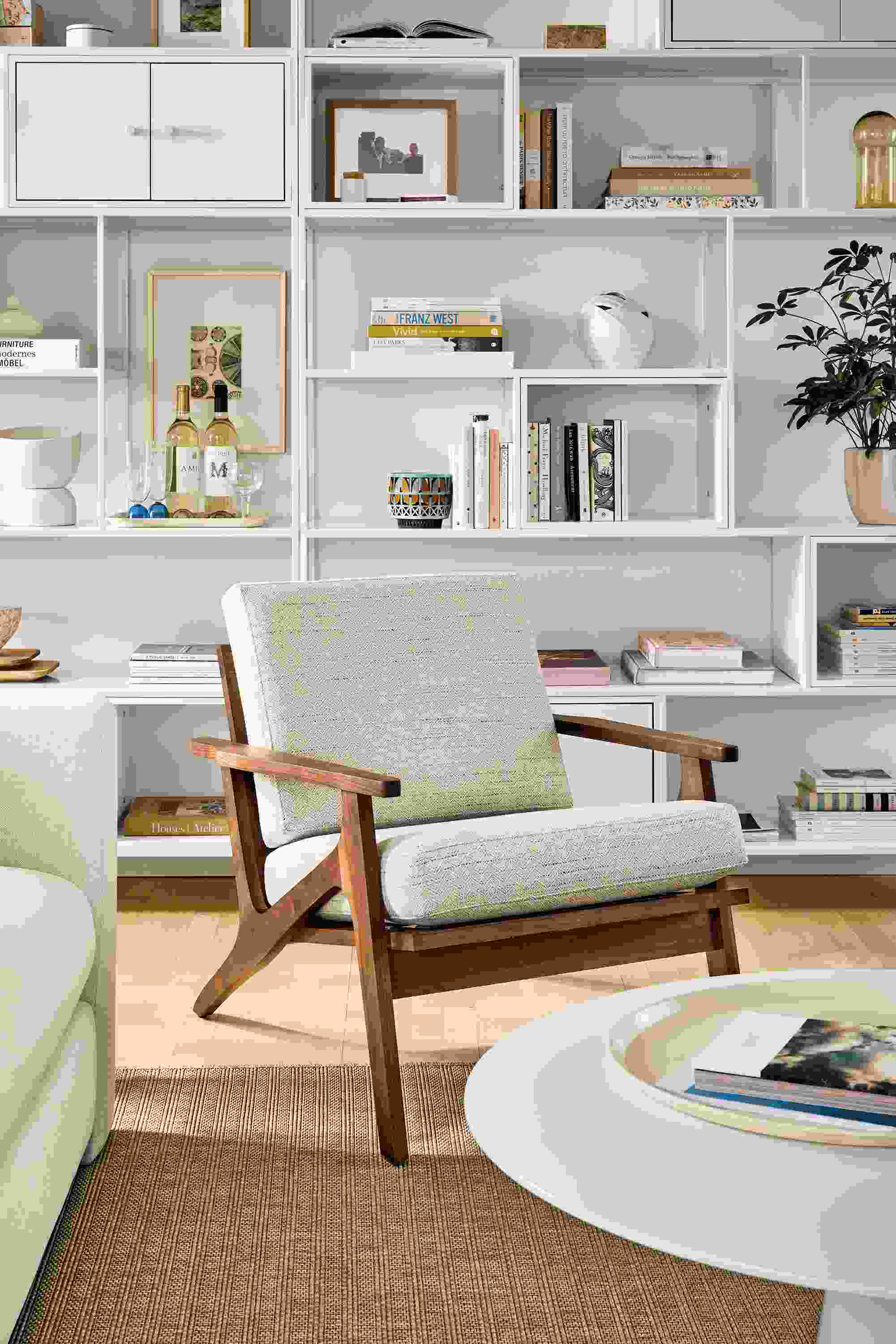 Living room with Sanna chair in Kinsey Oatmeal, Decker coffee table in white and foshay bookcases in white with white inserts.