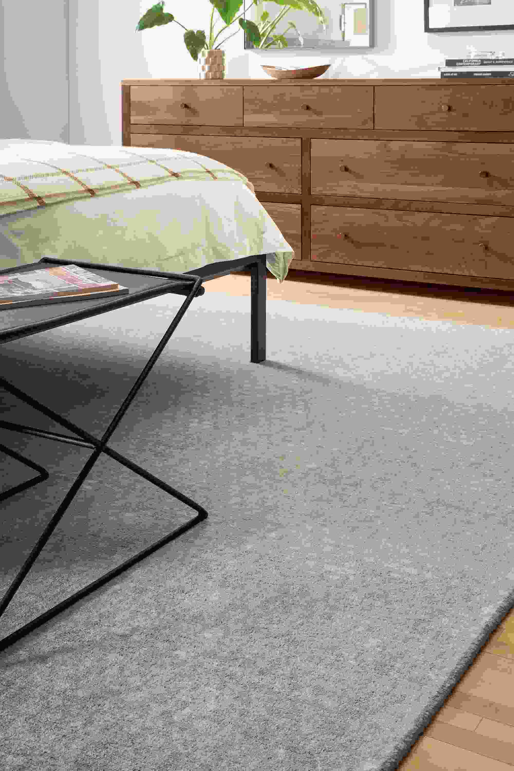 Detail of Saris 8x10 rug in grey in bedroom.