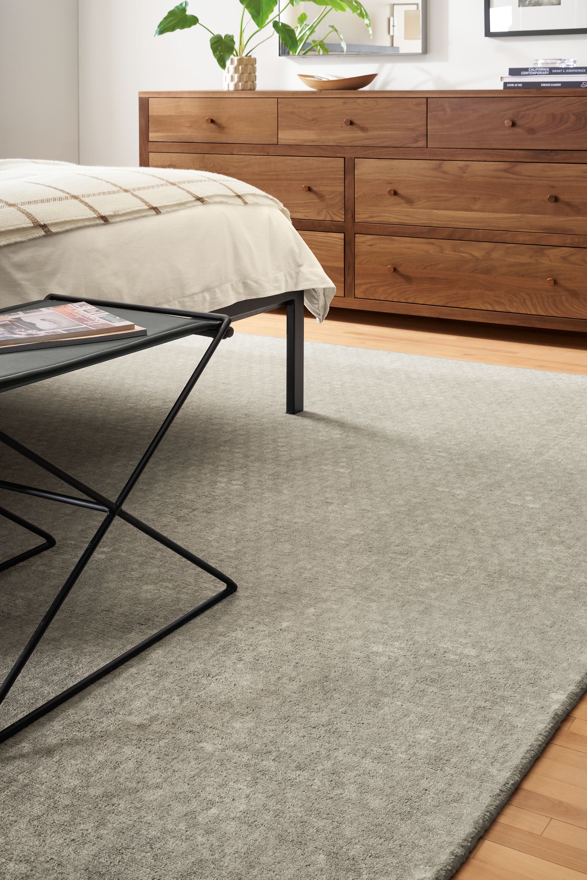 Detail of Saris 8x10 rug in grey in bedroom.