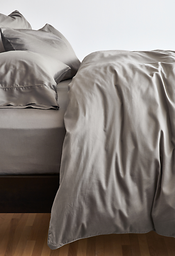 Detailed image of tailored sateen duvet cover and sheets in charcoal.