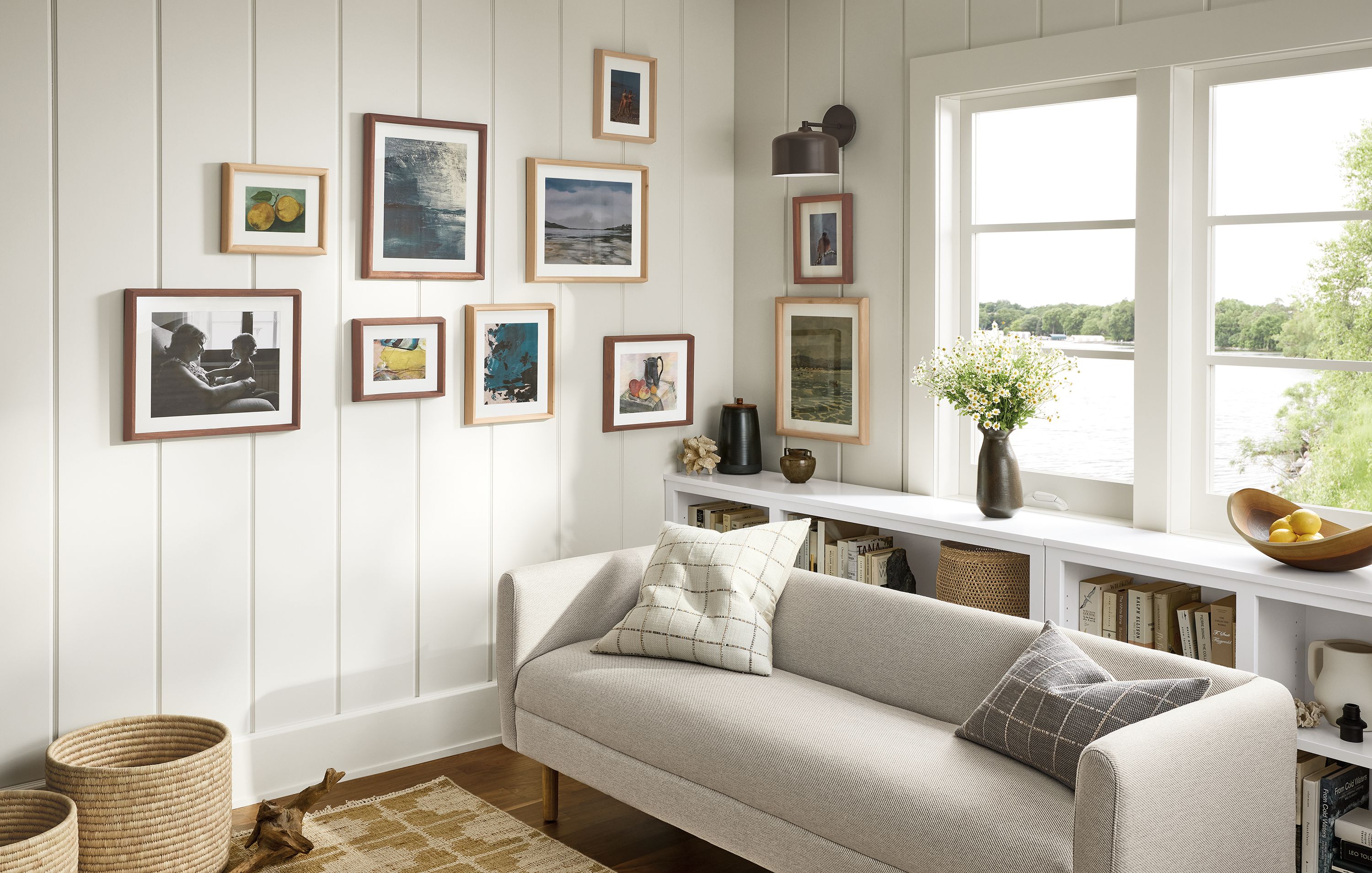 Living room with a Satler bench in derry natural and a collection of frames in walnut and cypress on the wall.