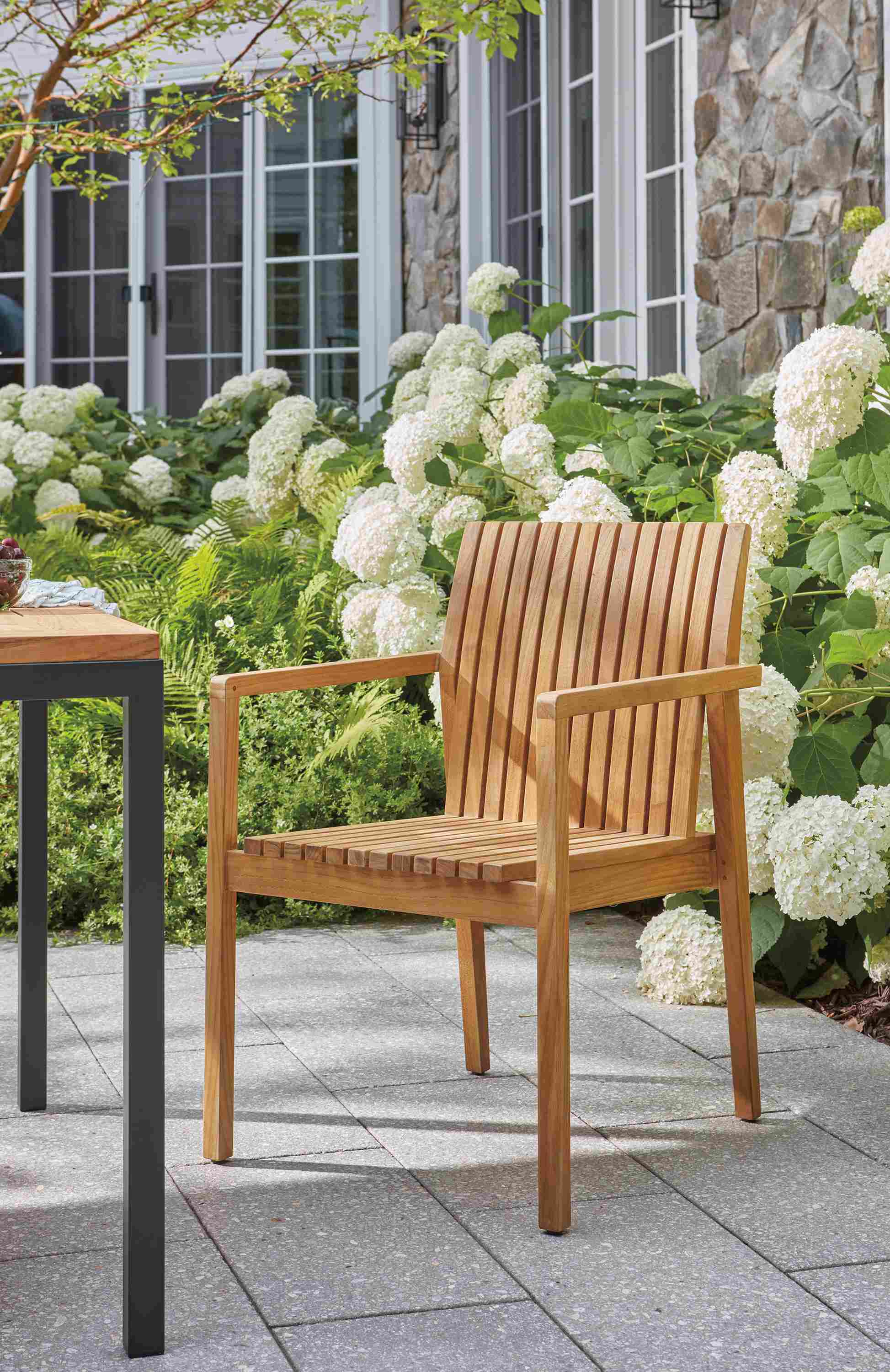 Patio with Savu arm chair in teak heartwood and Parsons table in teak heartwood and graphite.