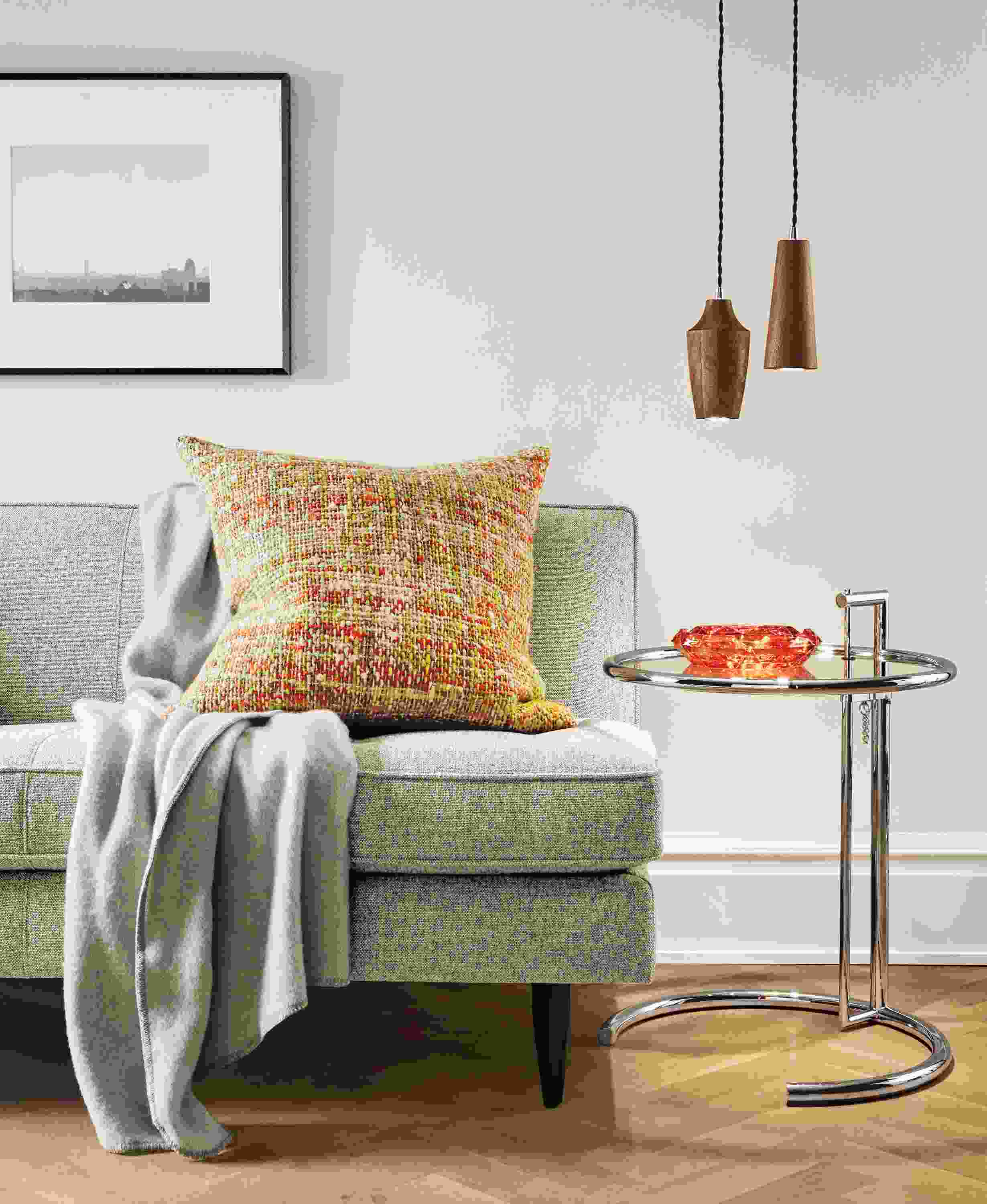 Detail of Scotland pillow in tangerine fabric on sofa.