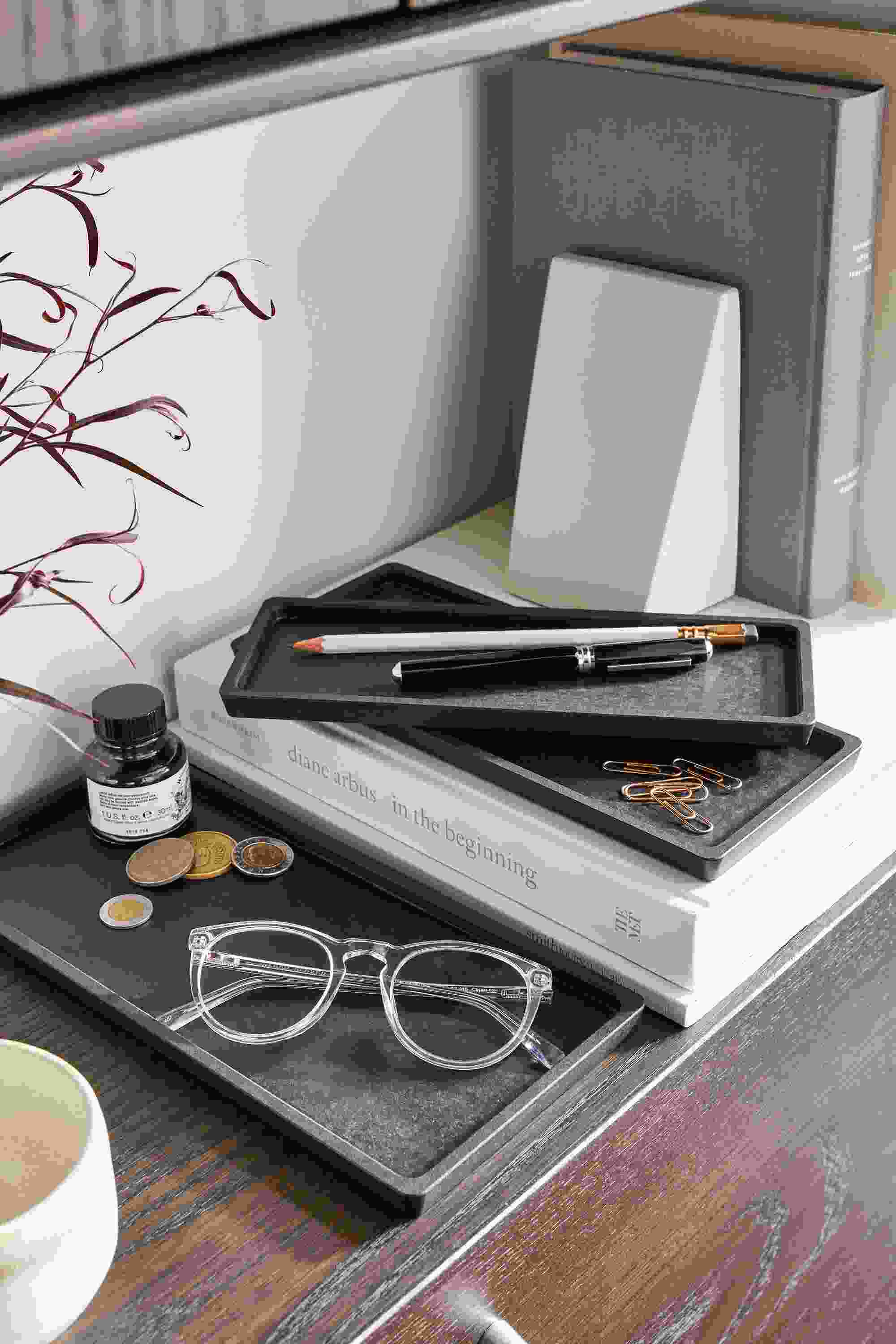 Detail image of sector nesting trays in slate and Edge bookends in white on a Beam bookcase in charcoal on ash.