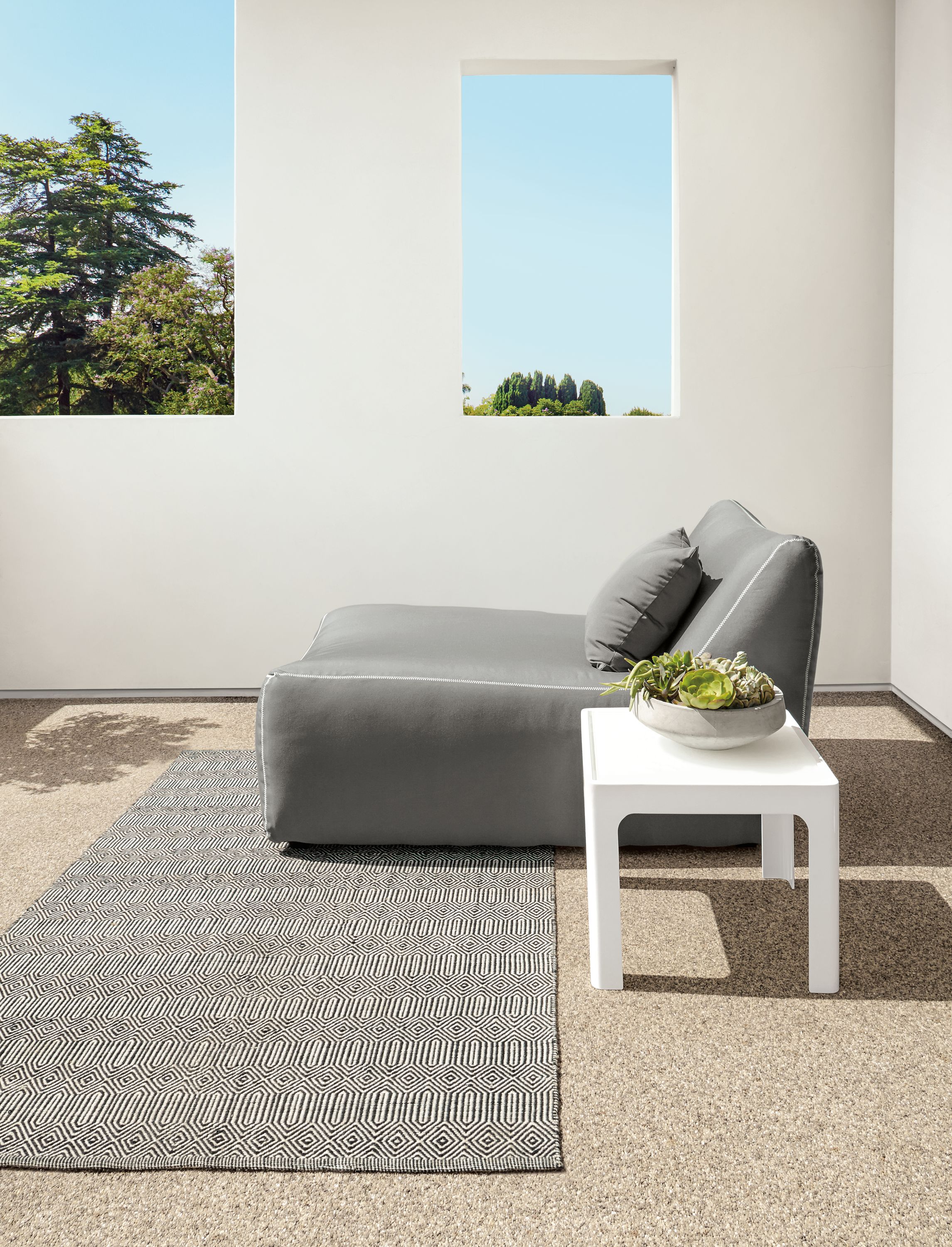 Outdoor space with Sequence rug in Ivory/Black and Maya chaise in Sunbrella Canvas Charcoal.