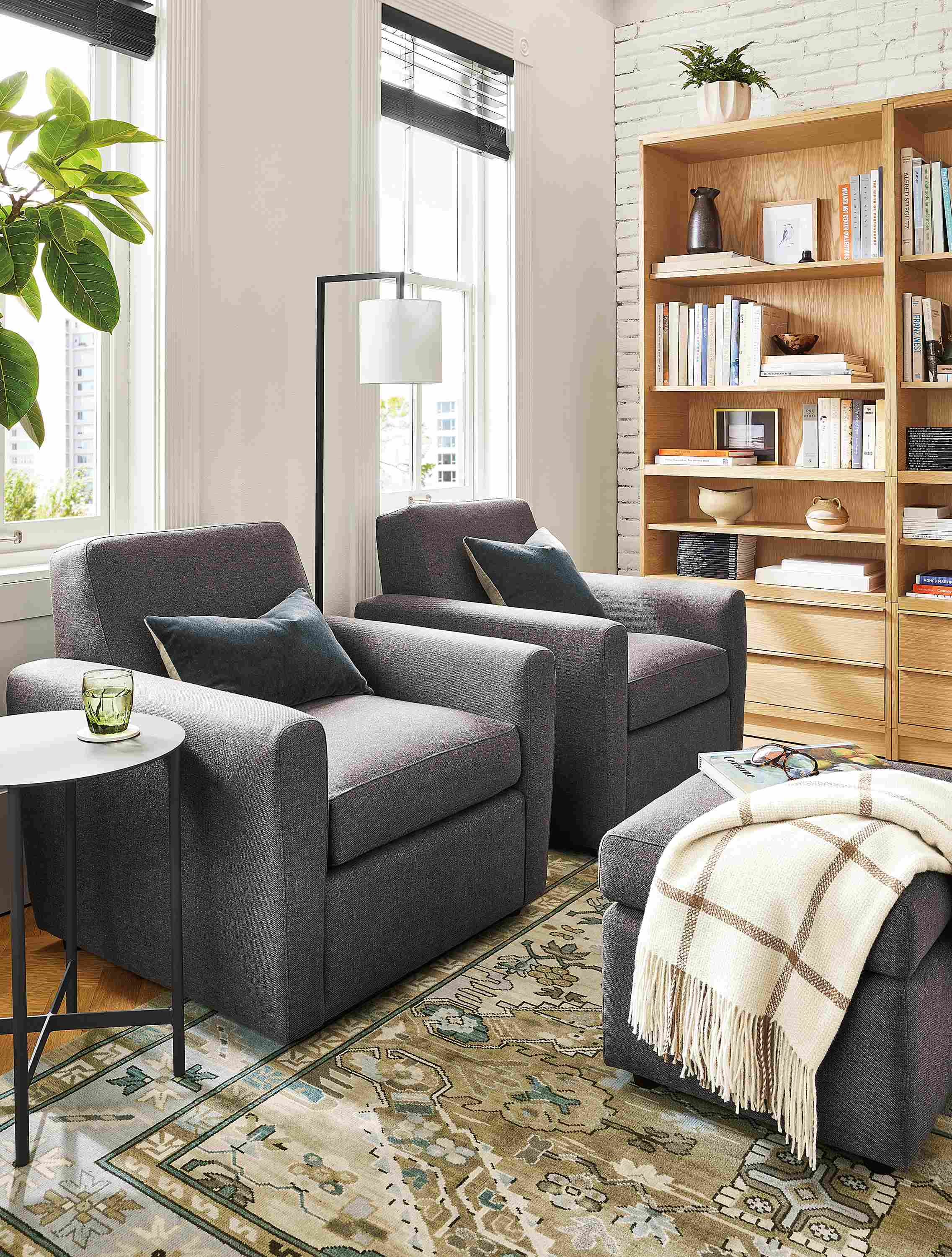 Living room with two Seth swivel chairs and Seth ottoman in Gino Charcoal, Kayseri rug, Vincent throw.