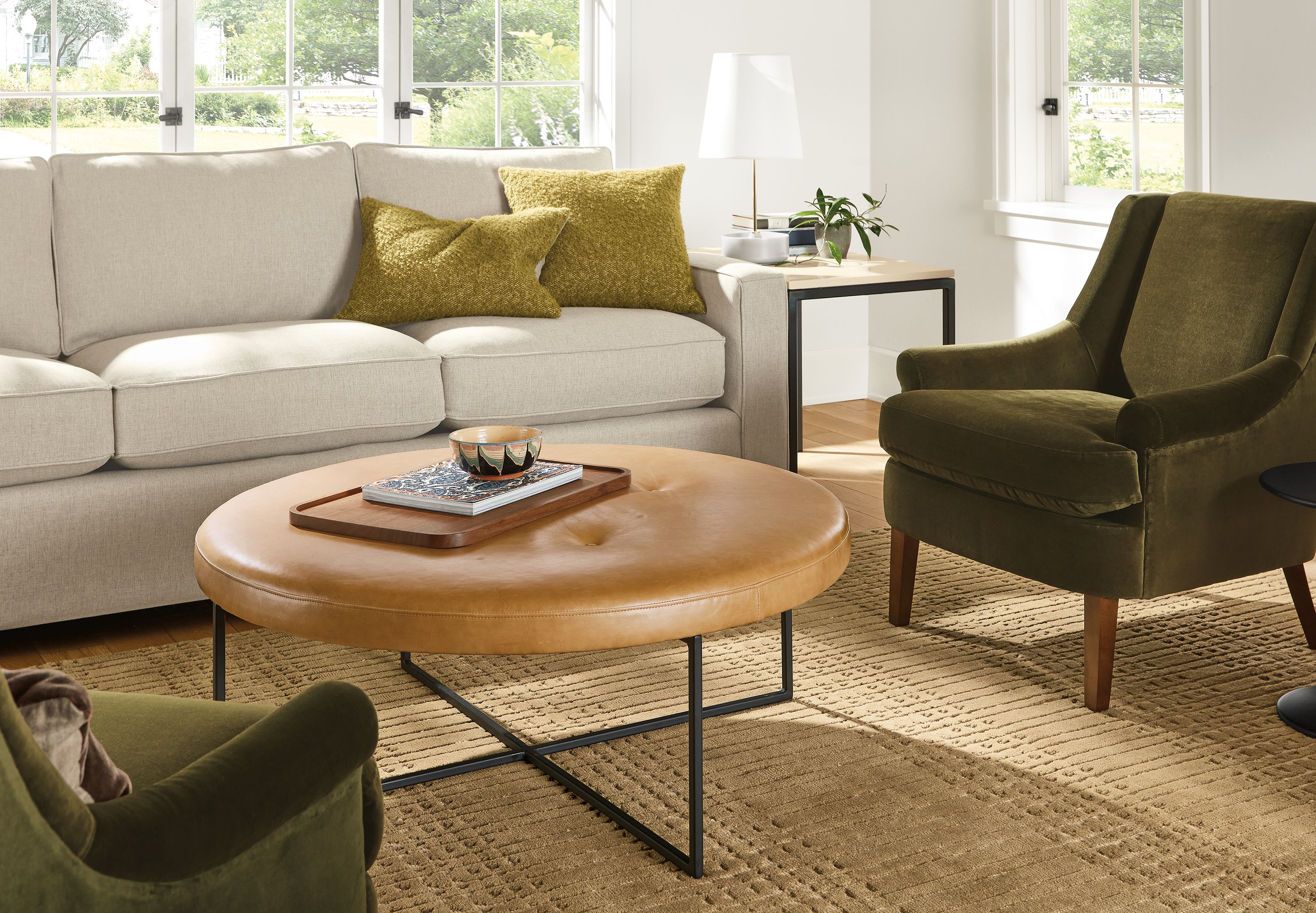 Living room with Sidney ottoman in Palermo Camel leather and York sofa in Sumner Linen.