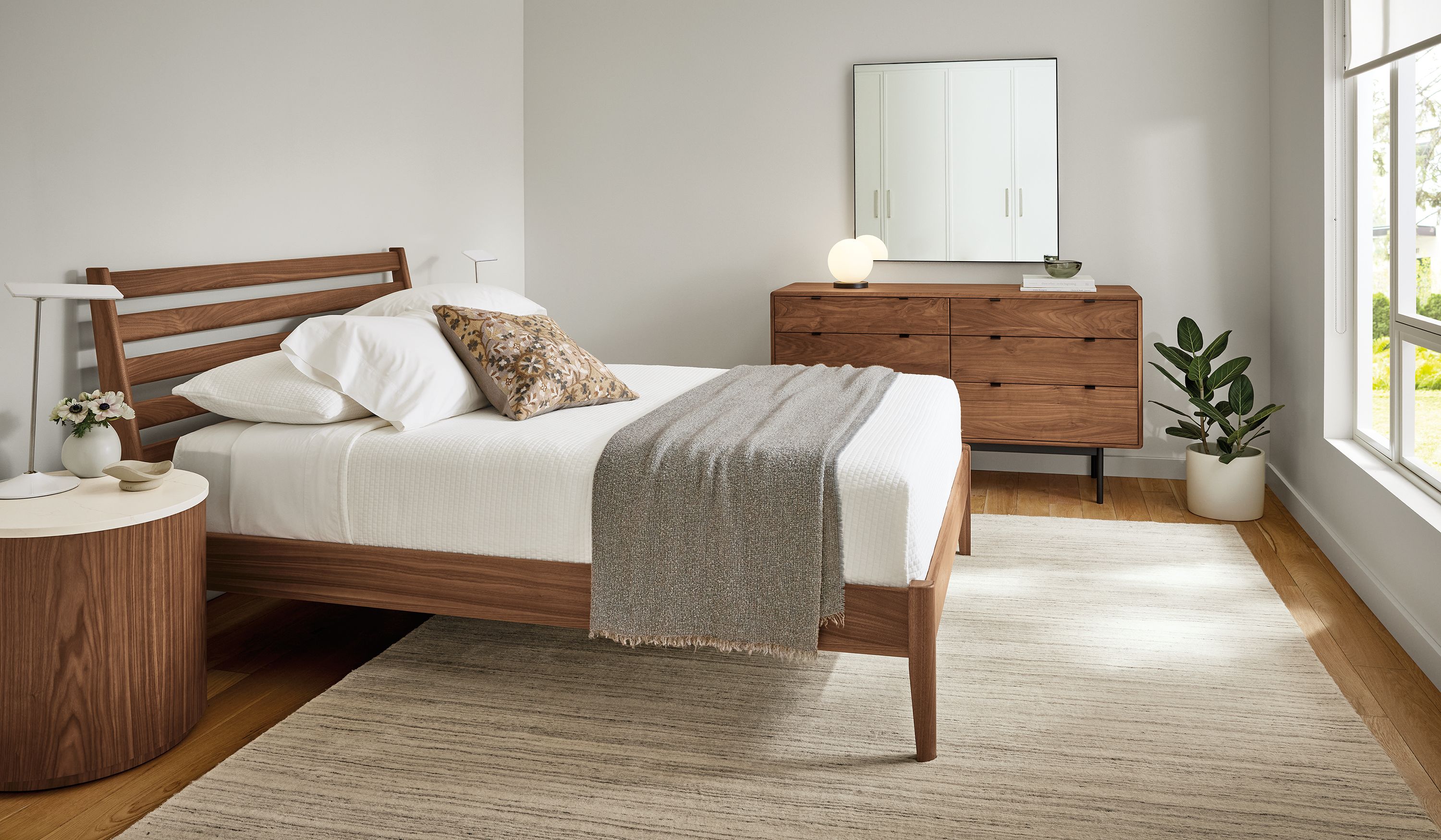 Bedroom with Silas queen bed, Hensley 6-drawer dresser and Liam round end table all in walnut finish.