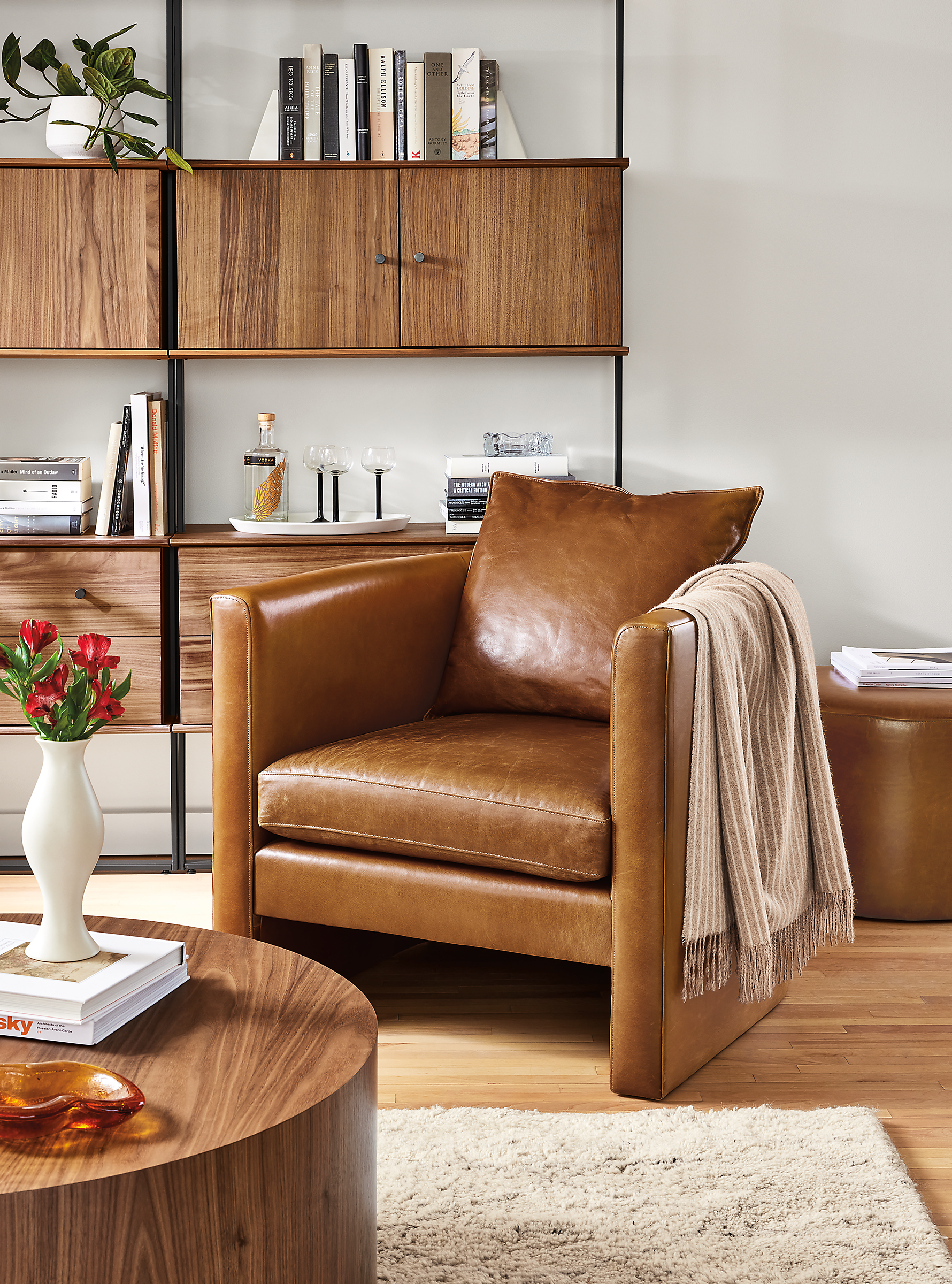 living room with silva chair in vento cognac leather, liam coffee table, beam bookcase wall unit.
