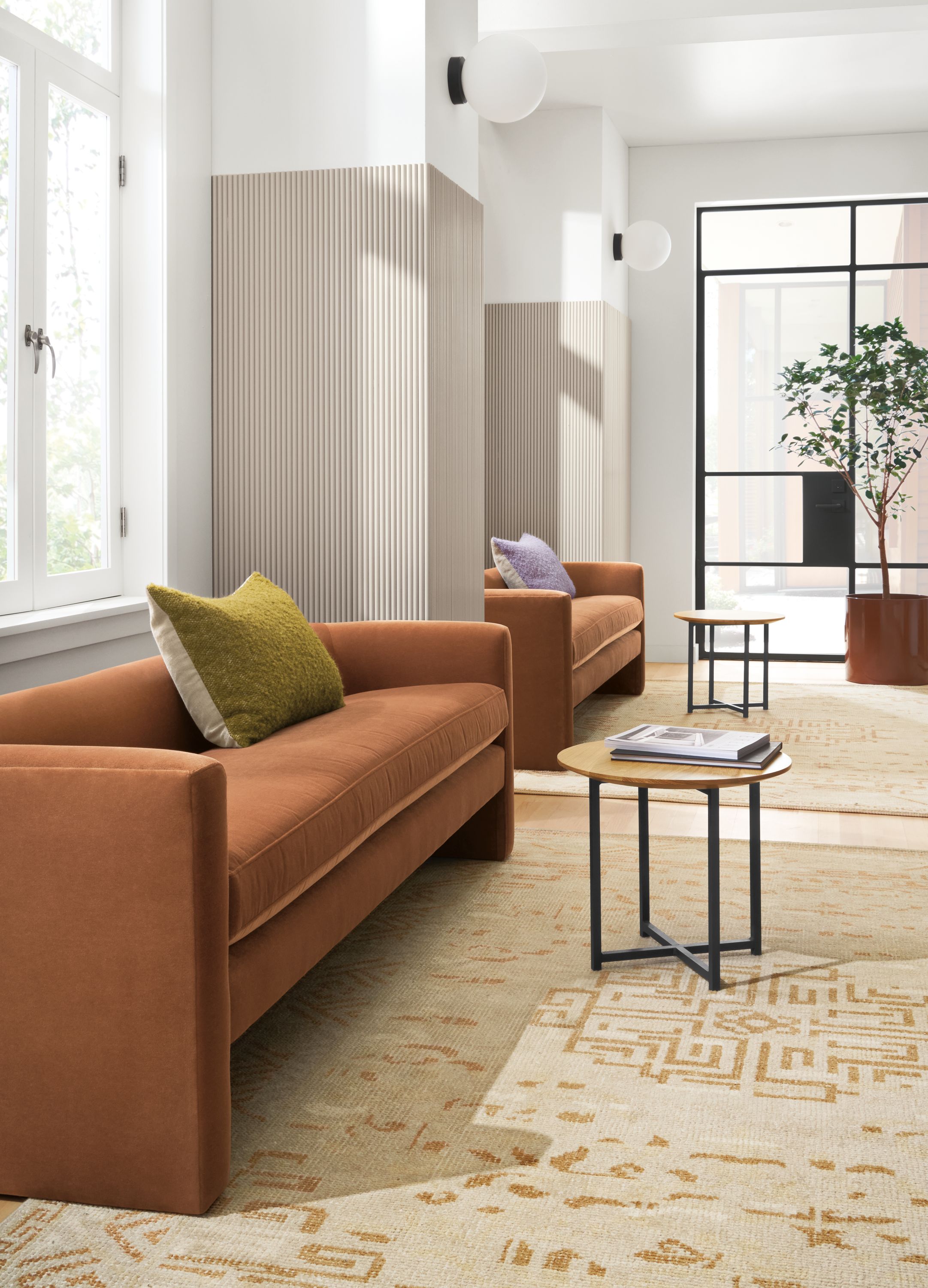 Business Interiors setting with silva 76-wide bench in banks cognac with classic end tables in natural steel.