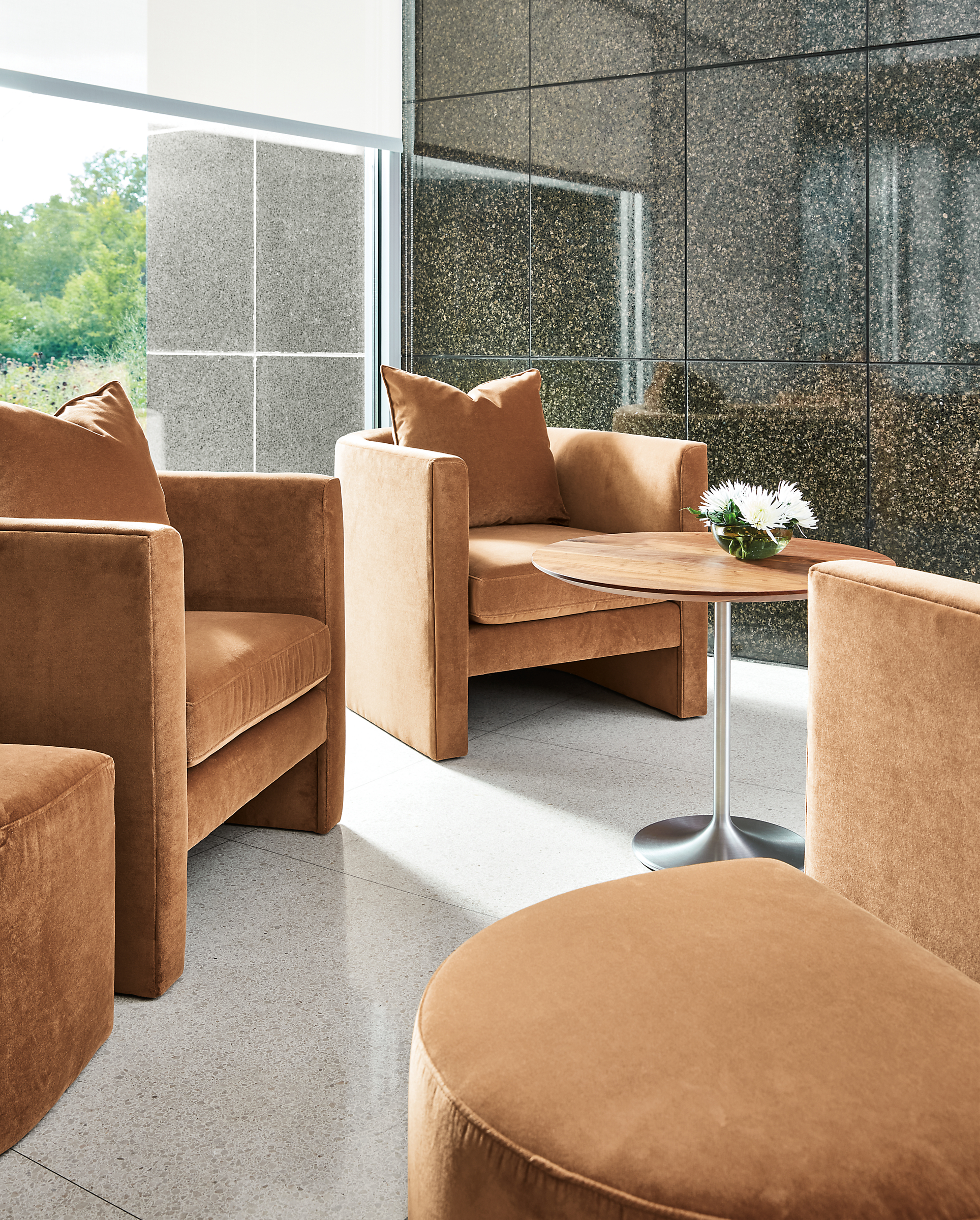 Business interiors setting with silva chairs and ottomans in banks cognac