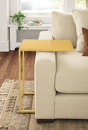 Detail of Slim C-table in Saffron beside taupe sofa.