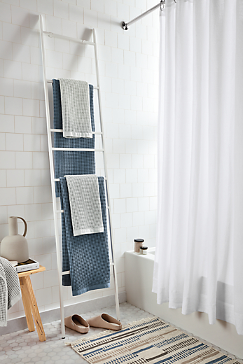 detail of slim towel ladder in white in bathroom.