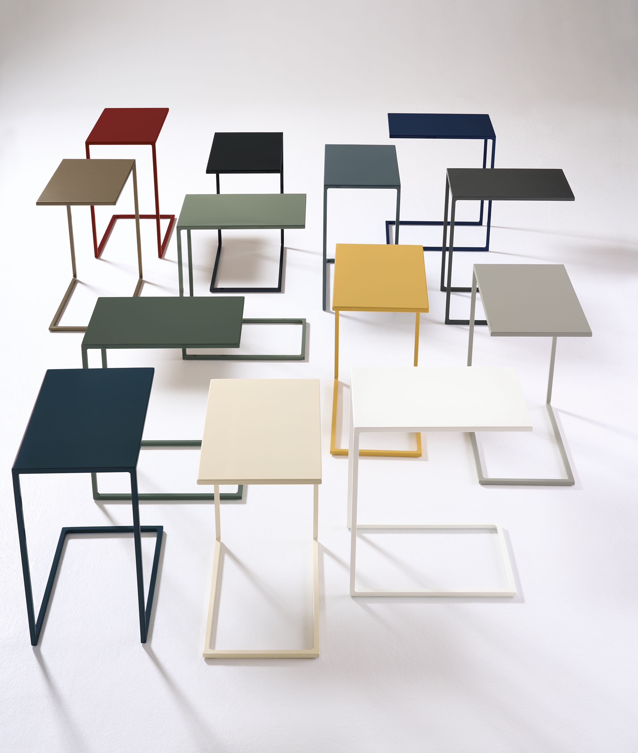 A group of Slim 13-wide C-shaped tables in various color options.