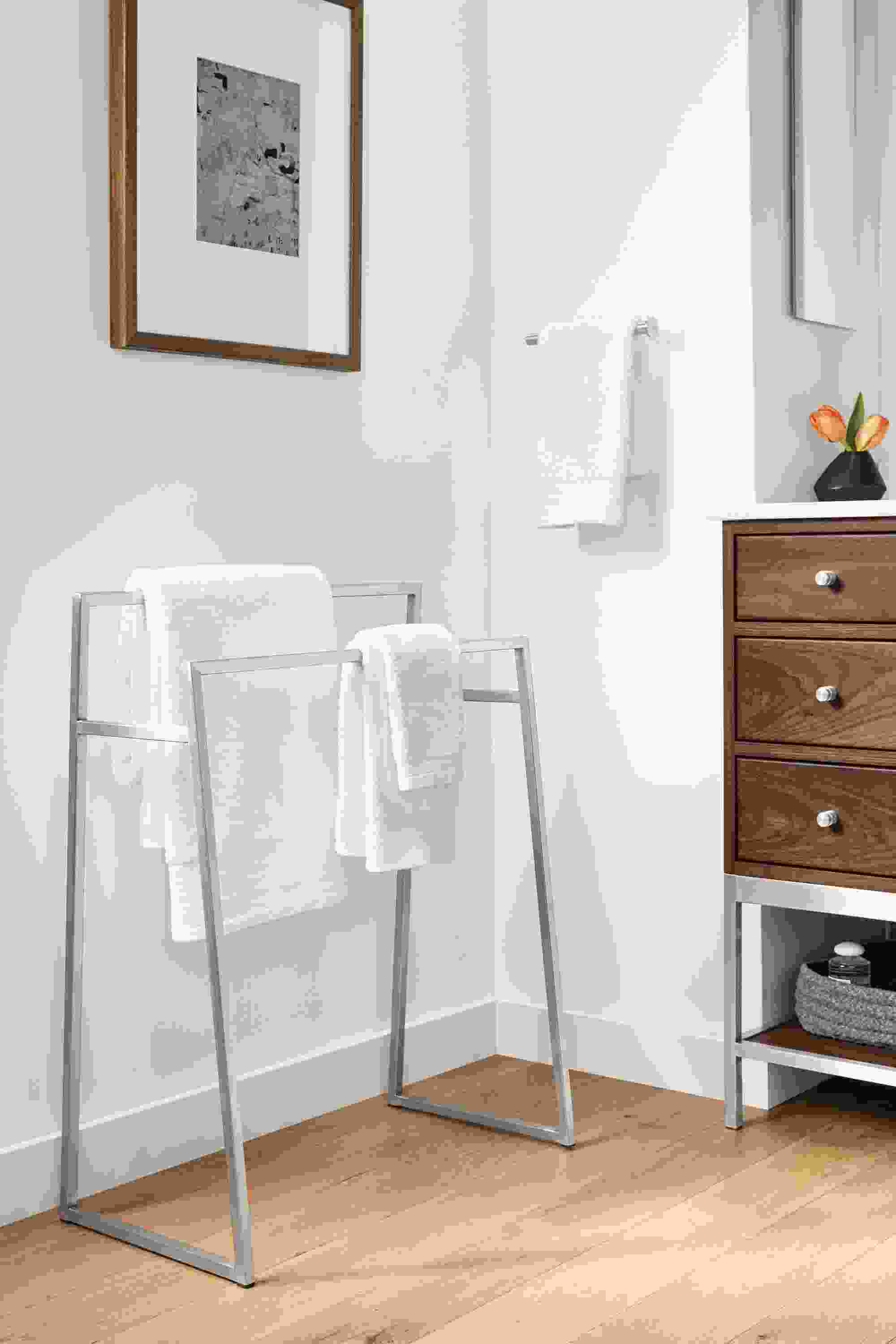 Detail of Slim freestanding towel rack in stainless steel in bathroom.