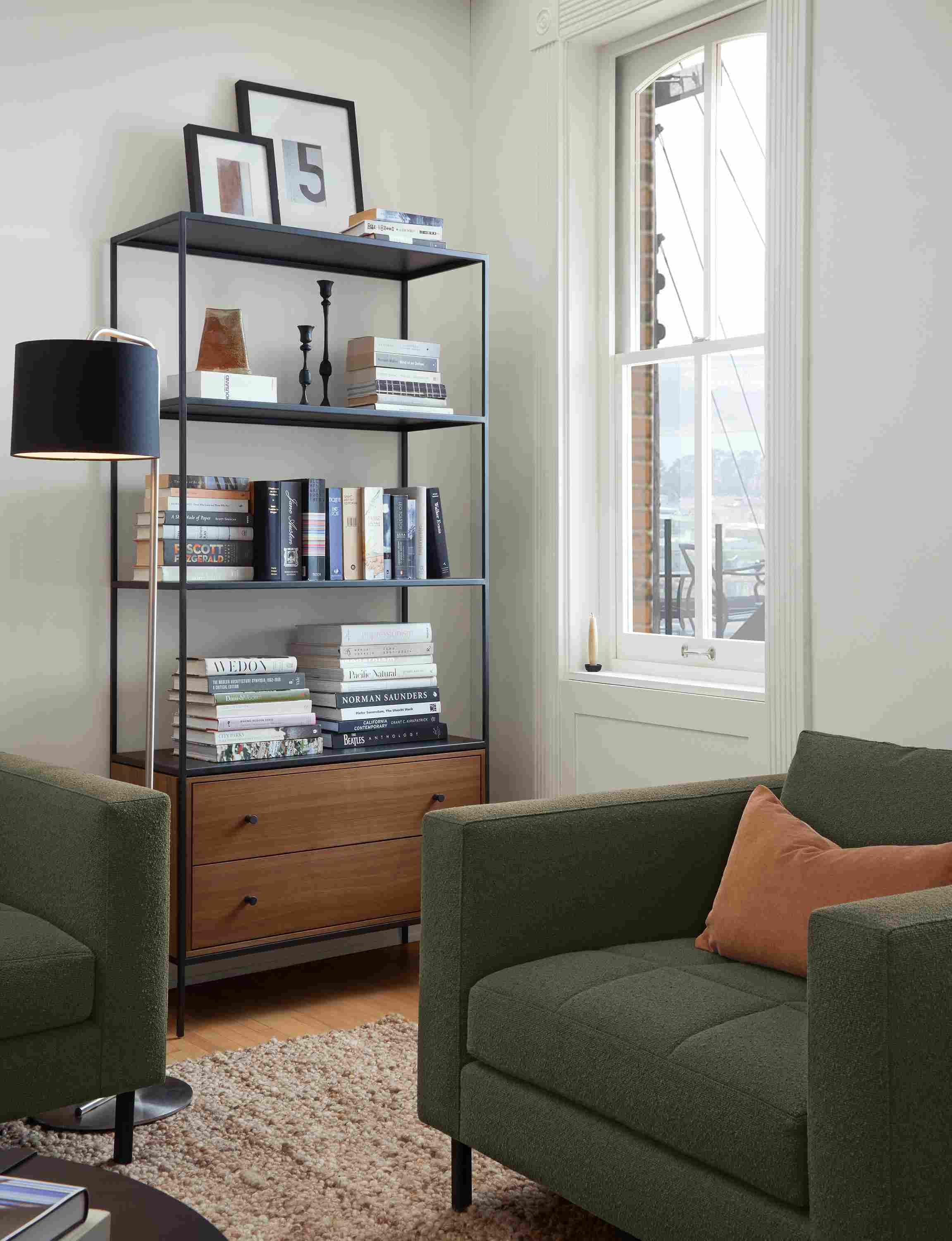 Apartment living room with Slim 2-drawer insert bookcase in natural steel and walnut and Lloyd sofa and chair in Declan Olive.