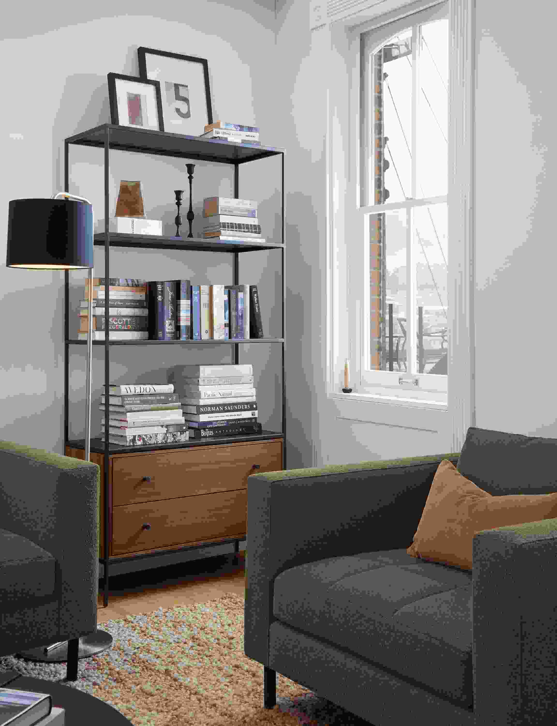 Apartment living room with Slim 2-drawer insert bookcase in natural steel and walnut and Lloyd sofa and chair in Declan Olive.