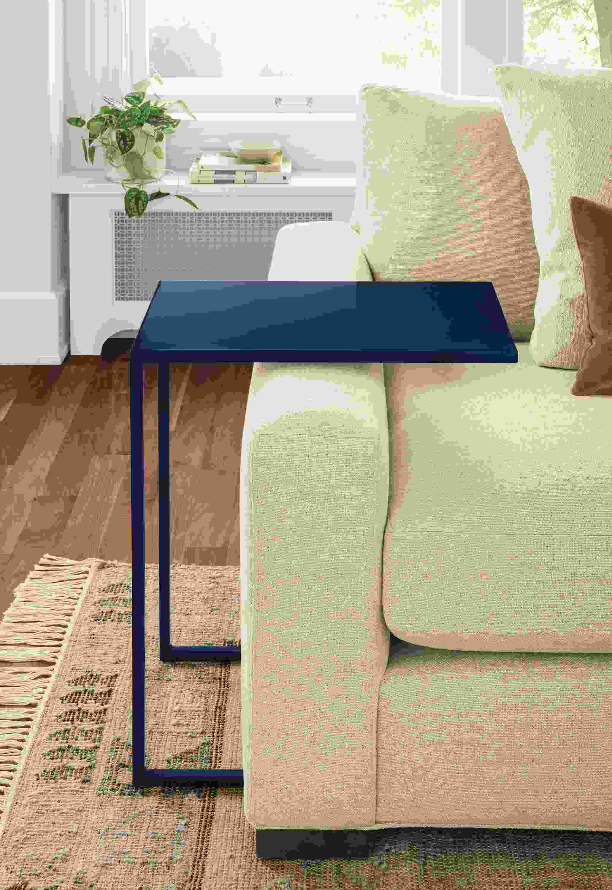 Detail of Slim C-table in Indigo beside taupe sofa.