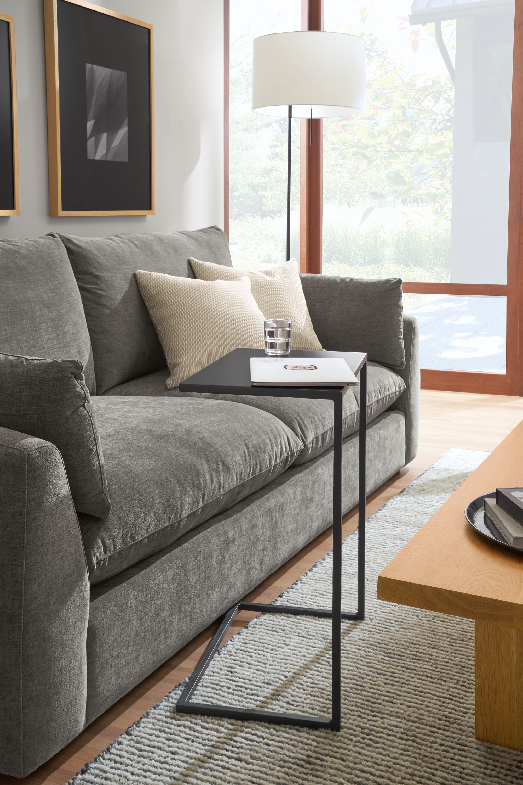 living room with slim 20-wide c-shaped table in natural steel and weber sofa in mori graphite fabric.