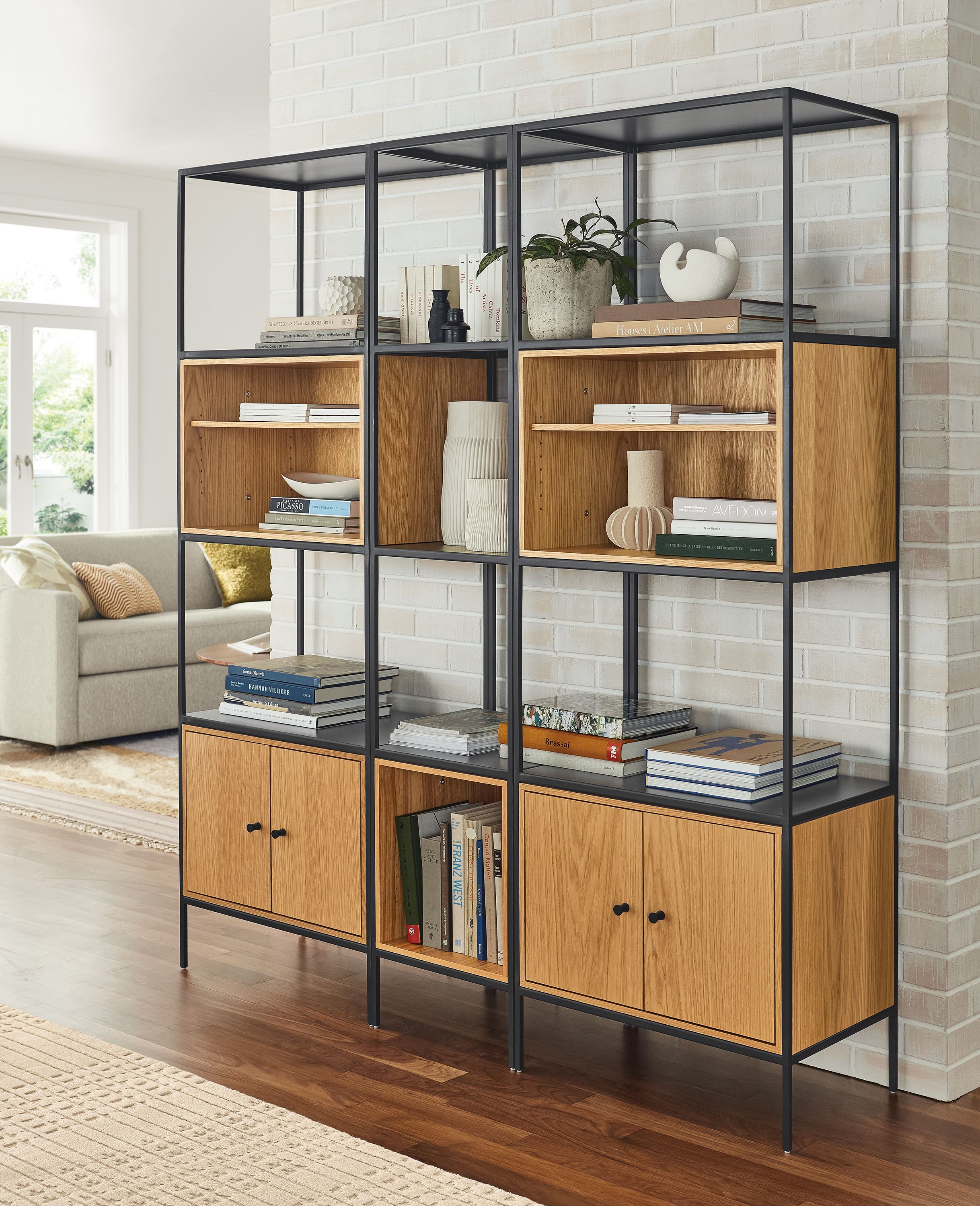 Living room with Slim 63 wide five insert wall unit in natural steel and white oak and Tova 8 by 10 rug in sand.