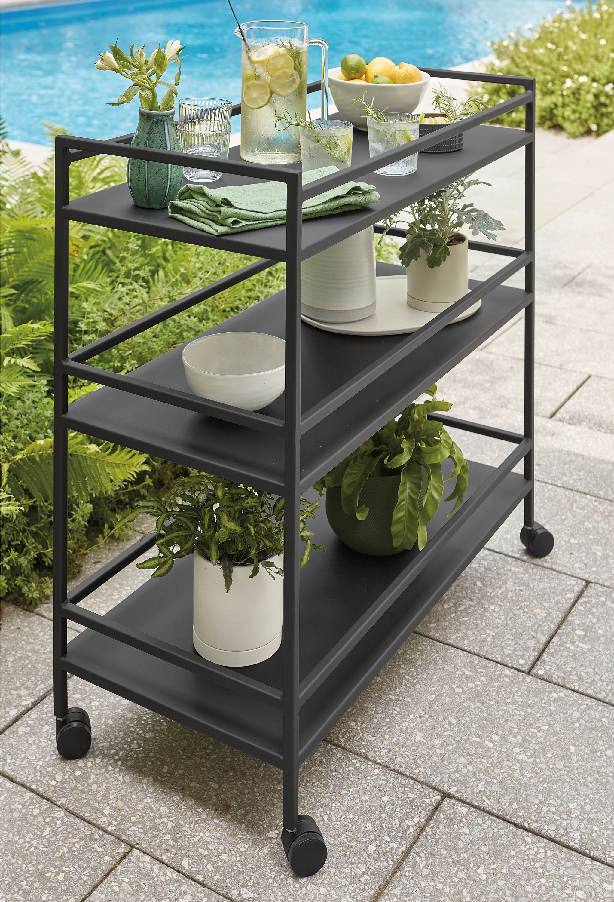 Patio with Slim outdoor bar cart in graphite and anya bowls in white.